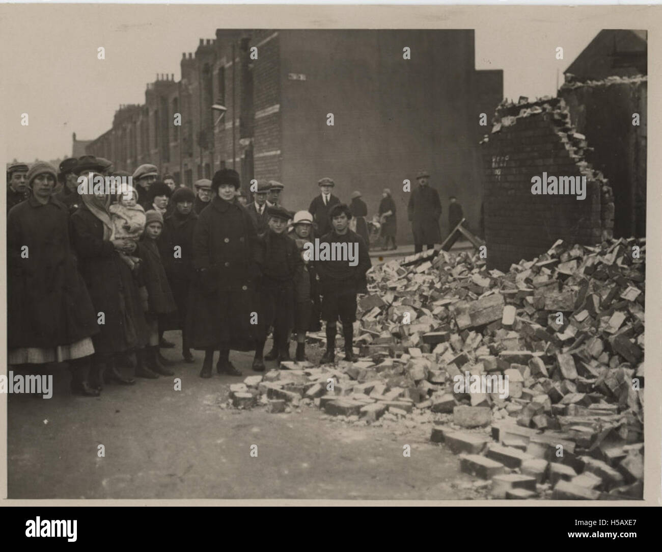 Dieses Foto zeigt einheimische Personen, die in der Nähe einer Ruine stehen. Die Szene stellt wahrscheinlich einen historischen oder ländlichen Kontext dar, in dem Gemeinschaften mit ihrer Umgebung interagieren und sich mit den Folgen von Zerstörung oder Naturereignissen auseinandersetzen. Stockfoto