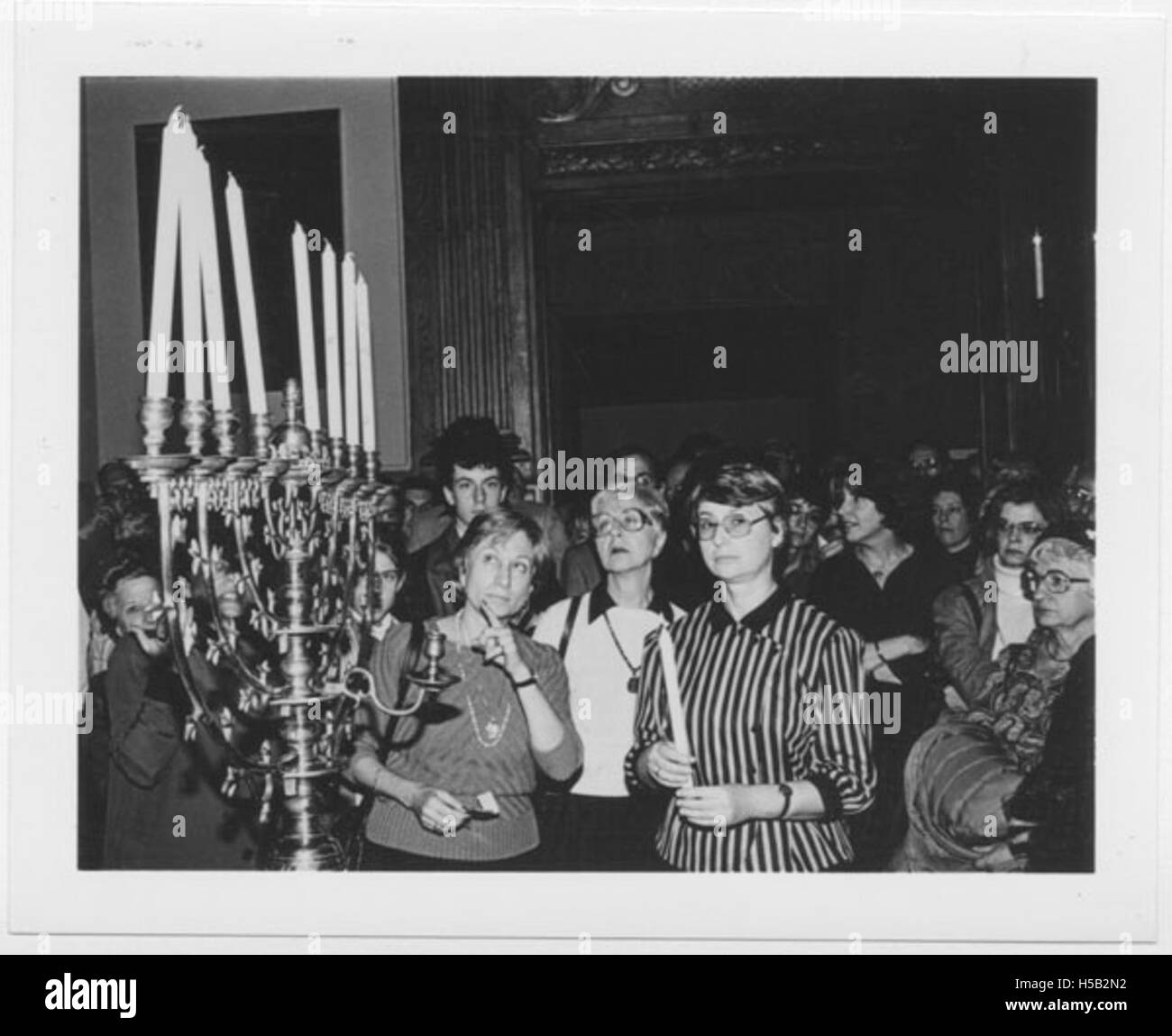 Feige Shkolnik, die Ehefrau von Isaak Shkolnik, einer prominenten Persönlichkeit der sowjetischen Judenbewegung, wird bei der Eröffnung des Jüdischen Museums in New York City mit einer Hannukiah beleuchtet. Dieses Bild verdeutlicht die Widerstandsfähigkeit von Verweigerungsleuten und ihre Rolle im politischen Aktivismus während der Sowjetzeit. Stockfoto