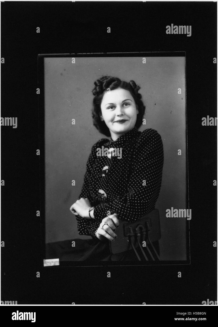 Dieses Porträtfoto fängt eine unbekannte Frau ein und bietet einen Einblick in Mode und Fotografie des 20. Jahrhunderts. Das Bild bietet einen historischen Kontext für das Erscheinungsbild der Frauen in dieser Zeit, obwohl ihre Identität unbekannt ist. Stockfoto