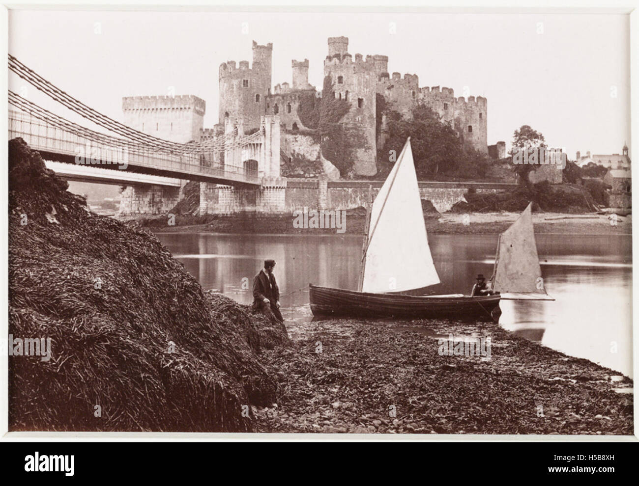 Foto mit Conway Castle und Suspension Bridge aus Sicht vom Landeplatz, wobei die architektonischen Merkmale beider Bauwerke hervorgehoben werden. Stockfoto