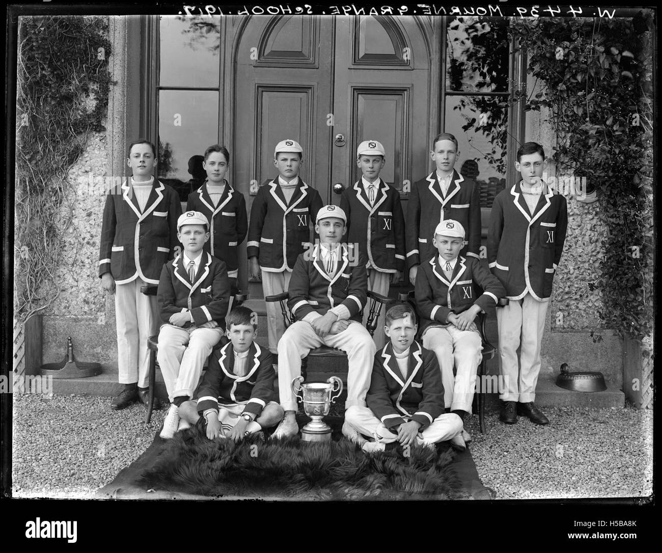 Das Cricket-Team der Mourne Grange School, das wahrscheinlich auf einem Foto aufgenommen wurde, repräsentiert die Teilnahme der Schule an Sportveranstaltungen und zeigt Schülerinnen und Schüler in einer historischen Umgebung. Stockfoto
