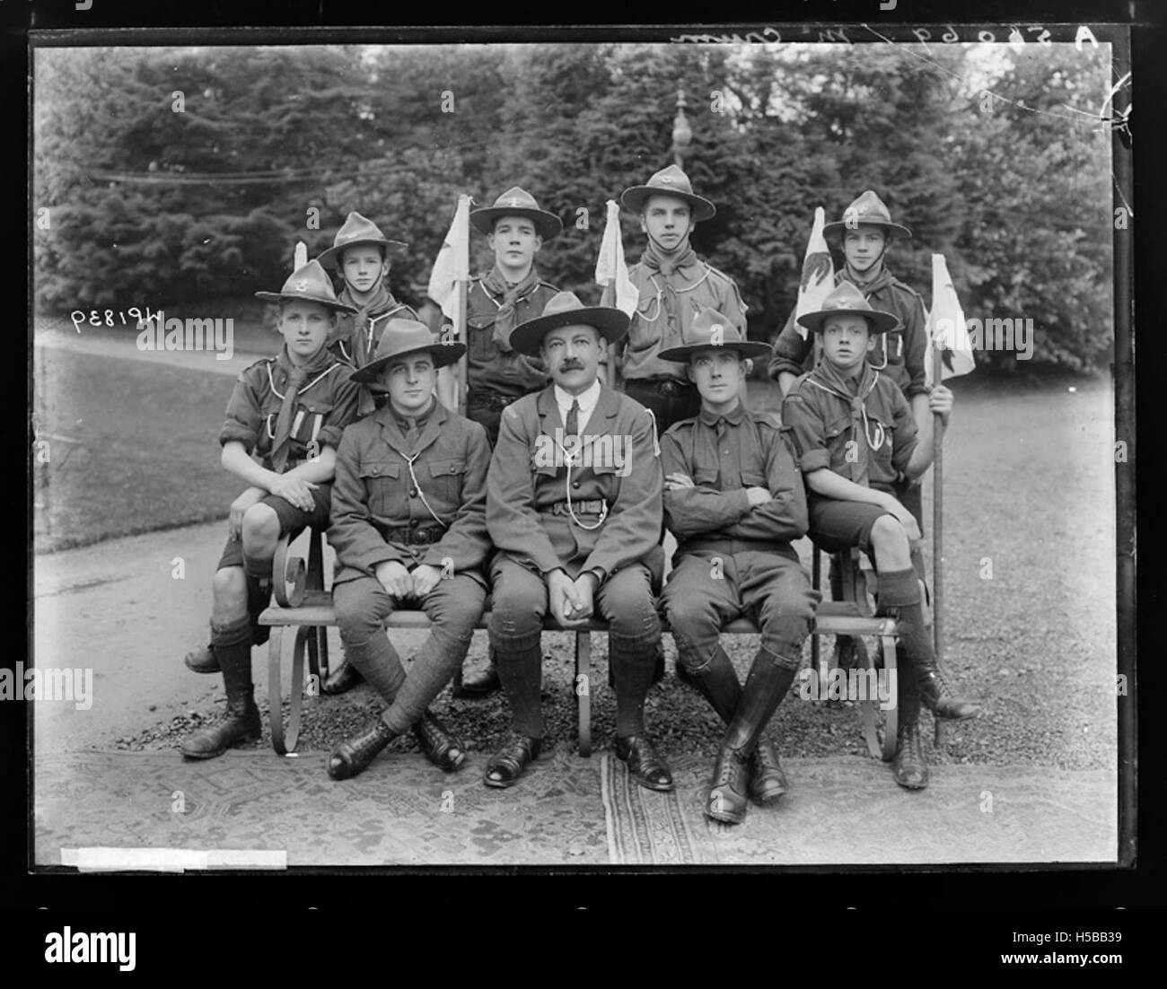 Dieses Bild zeigt eine Gruppe von Pfadfindern mit ihrem Vorgesetzten, die wahrscheinlich während eines Pfadfindereignisses oder einer Besprechung aufgenommen wurden. Scouts-Organisationen widmen sich der Jugendentwicklung und den Fähigkeiten im Freien. Stockfoto