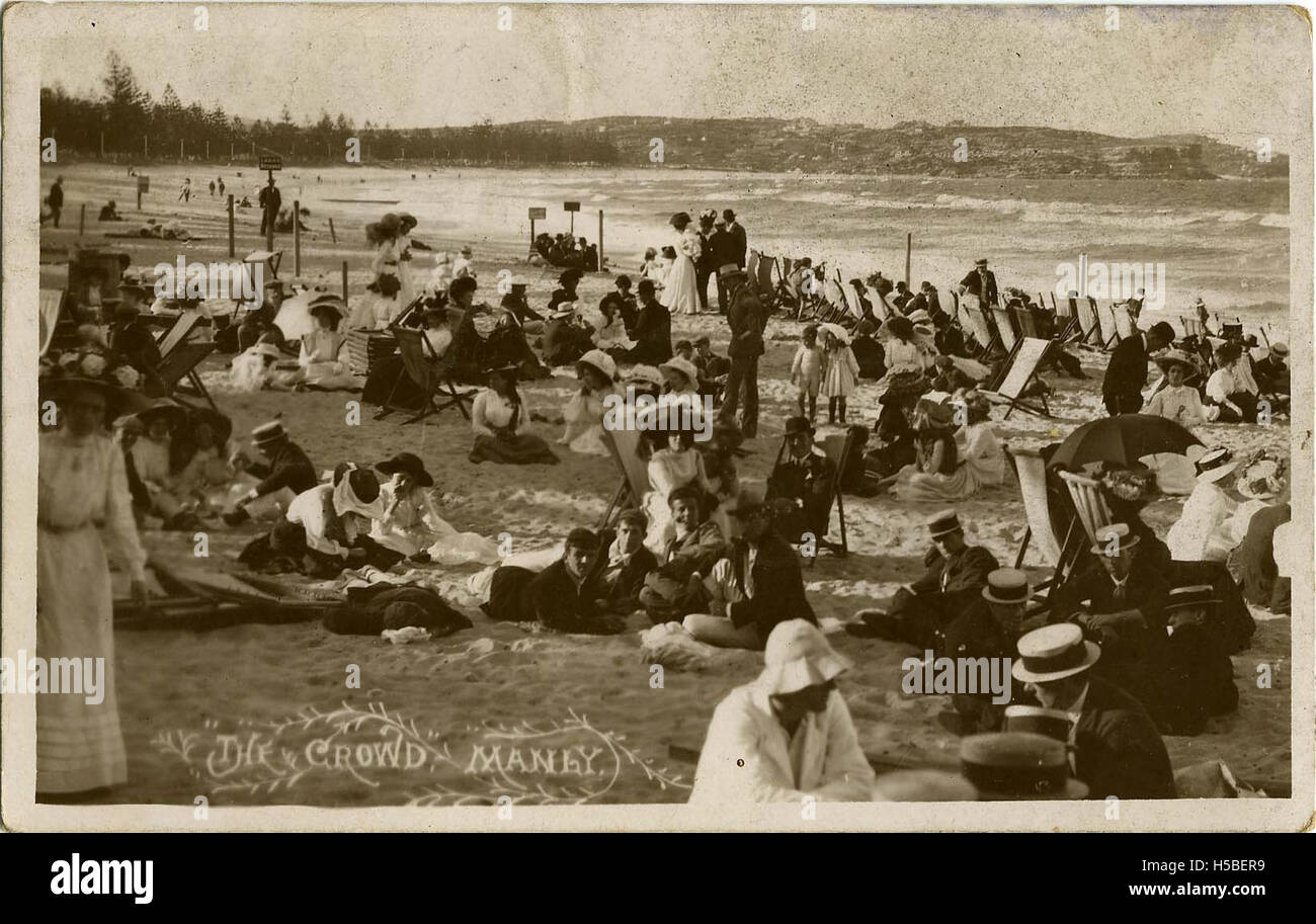 Diese fotografische Postkarte mit dem Titel „The Crowd, Manly“ zeigt eine lebhafte Szene von Menschen, die sich in Manly, einem beliebten Vorort in Sydney, Australien, versammelt haben. Das Bild spiegelt wahrscheinlich die geschäftige Atmosphäre der Gegend wider, möglicherweise während eines Festivals oder einer öffentlichen Veranstaltung. Stockfoto