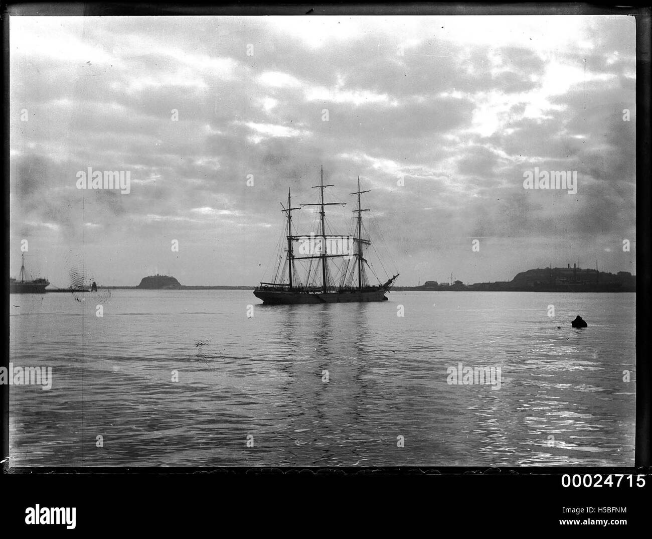 Eine Dreimastbarke vor Anker im Hafen von Newcastle, New South Wales, zeigt die maritimen Aktivitäten in der Region. Dieses Segelschiff repräsentiert die historische Bedeutung des Seehandels in der Region im 19. Und frühen 20. Jahrhundert. Stockfoto