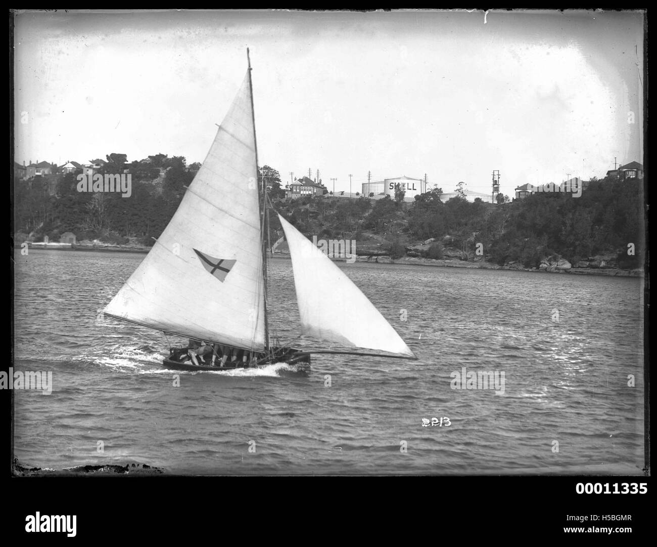 Dieses Foto zeigt ein 10-Fuß-Schiff, das sich möglicherweise in der Nähe von Gore Cove im Hafen von Sydney befindet. Es unterstreicht die Präsenz des kleinen Bootes auf einer der wichtigsten Wasserstraßen Sydneys. Stockfoto
