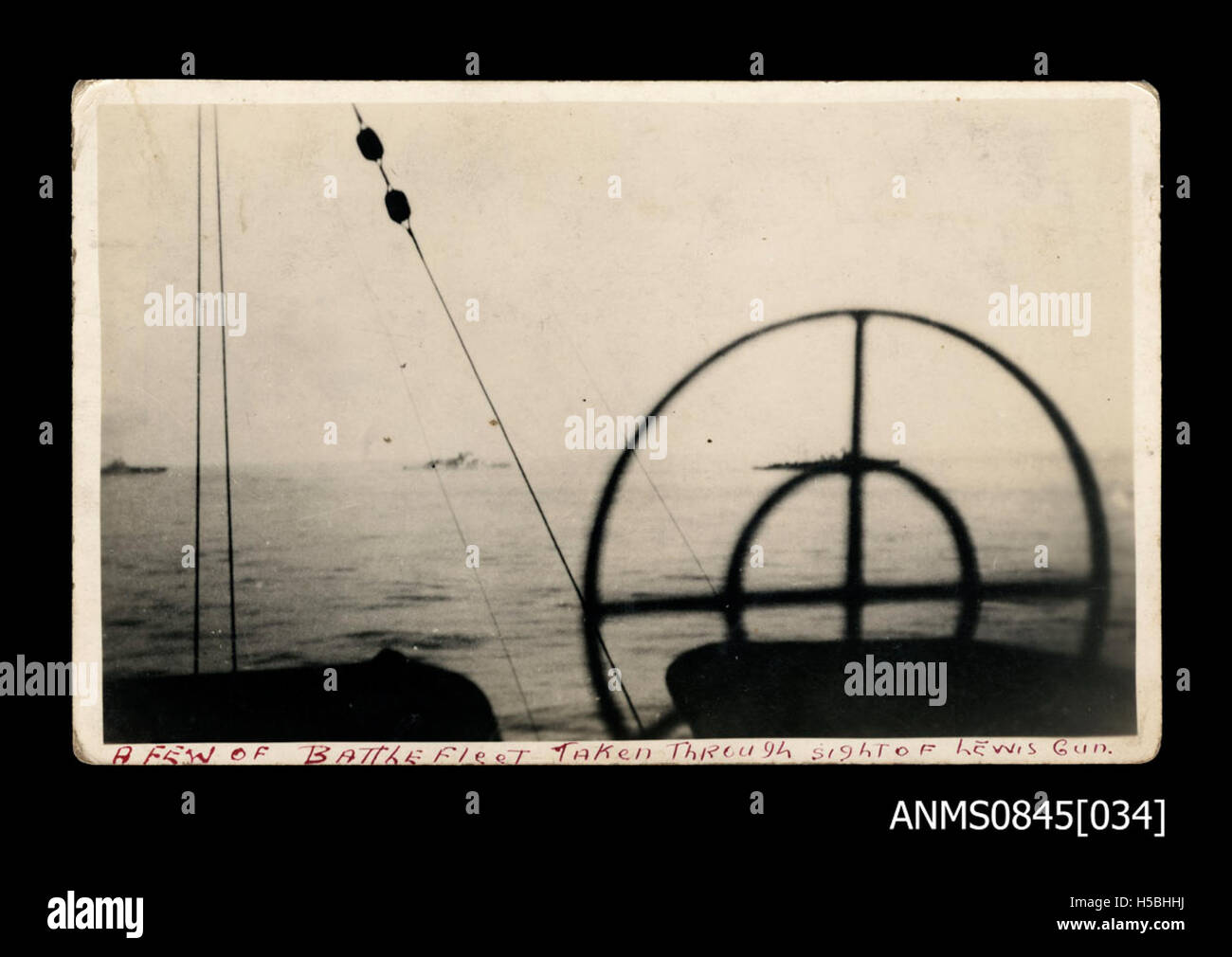 Dieses Bild zeigt eine Kriegsflotte durch den Anblick einer Lewis-Kanone, einer Art leichter Maschinengewehre, die Anfang des 20. Jahrhunderts, oft im Ersten und Zweiten Weltkrieg, verwendet wurde. Die Perspektive betont wahrscheinlich den militärischen Aspekt der Flotte aus Sicht des Schützen. Stockfoto