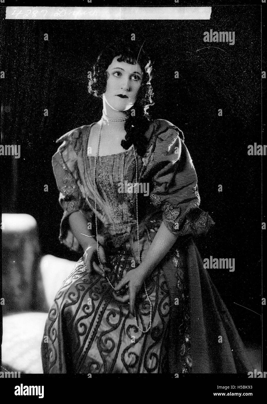 Dieses Porträt zeigt eine Frau im historischen Kostüm, möglicherweise eine Schauspielerin aus einer bestimmten historischen Periode. Die Kleidung deutet darauf hin, dass das Bild im späten 19. Oder frühen 20. Jahrhundert aufgenommen wurde, möglicherweise aus einer Theatervorstellung oder einem Film. Stockfoto