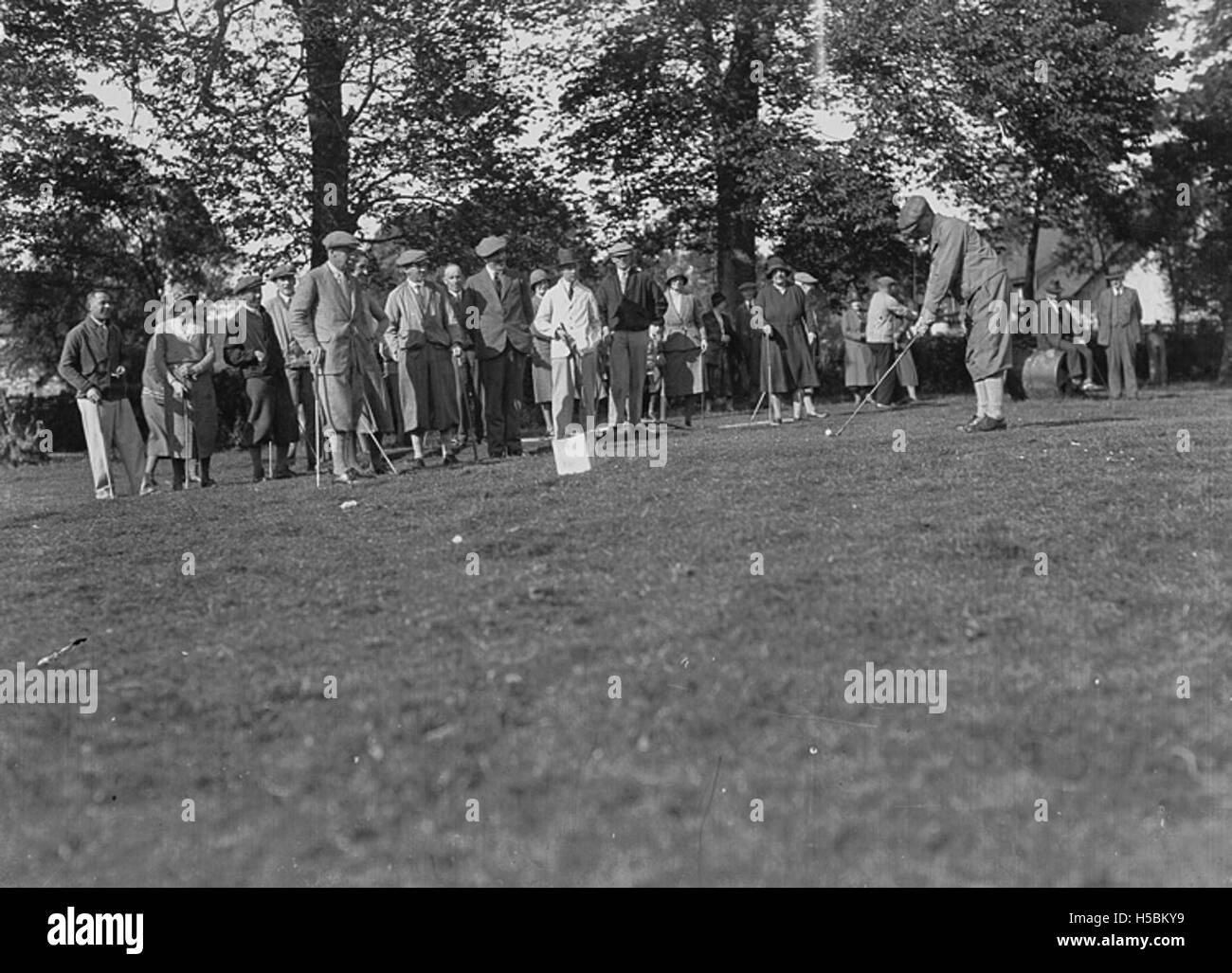 Fotografieren Sie Golfspieler und Zuschauer auf einem Fairway und veranschaulichen Sie ein Golfereignis. Stockfoto