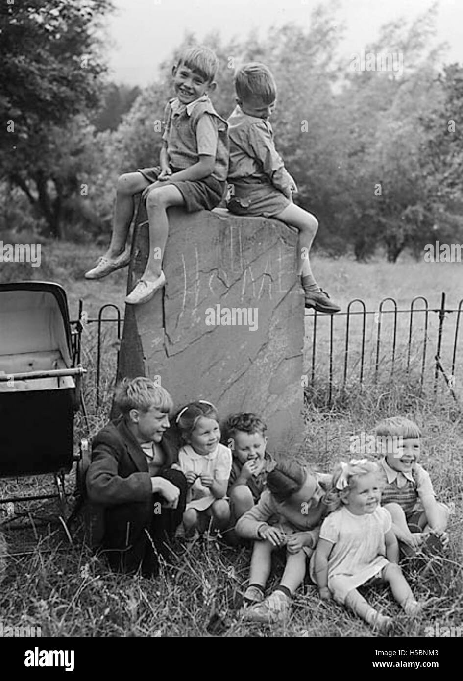 Kinder sind auf dem Logan Stone in Caerphilly, Wales, zu sehen. Der Logan Stone ist ein historisches Wahrzeichen, berühmt für sein Gleichgewicht und seine Verbindung mit walisischem Erbe und Folklore. Stockfoto
