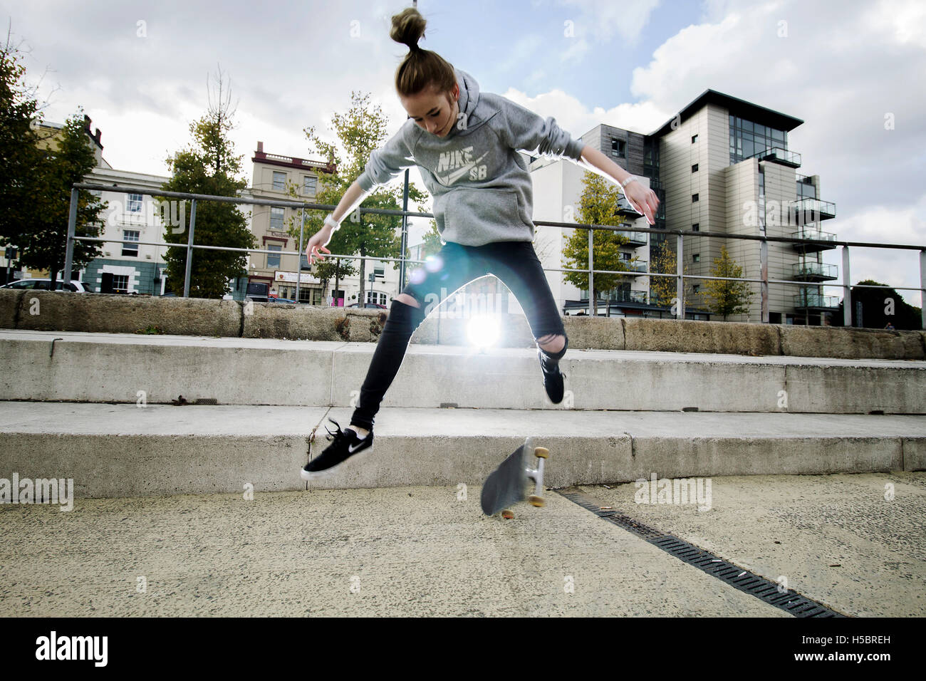 Romi Lewis, 17 von Blackwood, tun einen Kick flip Trick auf ihr Skateboard in Cardiff Bay. Genommen von Chloe Jackson-Nott. Stockfoto