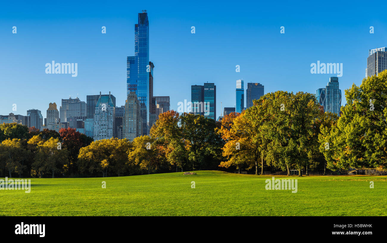 Central Park Sheep Meadow mit vollen Herbstfarben. Midtown Manhattan Wolkenkratzer im frühen Morgenlicht. New York City Stockfoto