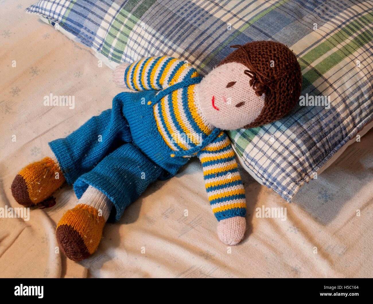 Vintage Handarbeit gestrickte Puppe auf ungemachten Bett Stockfoto