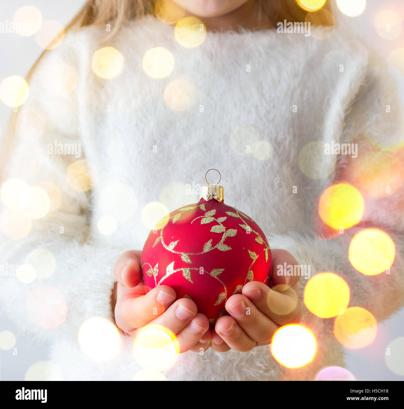 Kind hält rote Weihnachtskugel Stockfoto