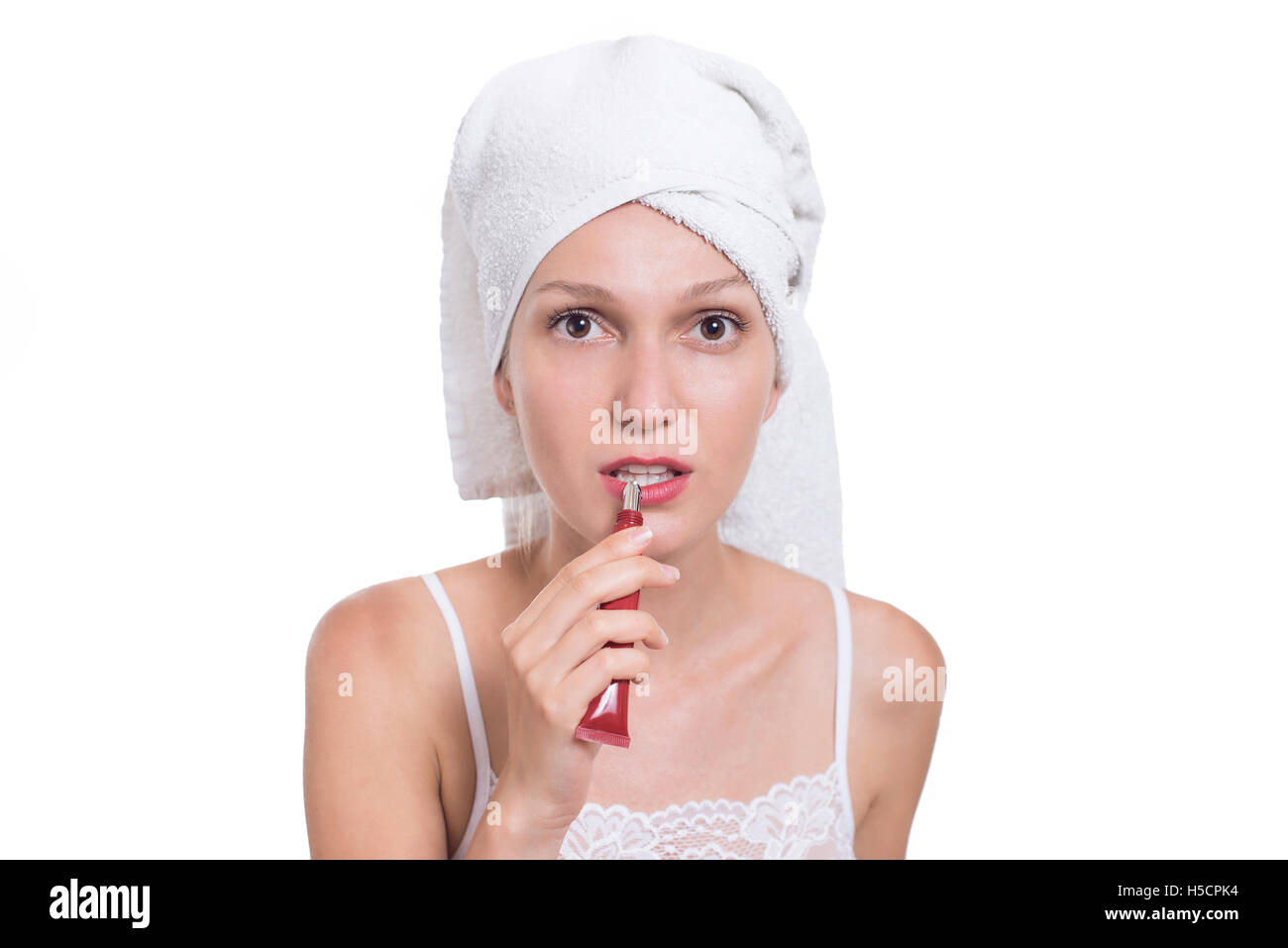 Junge Frau setzen Lippenstift, Lippenbalsam Lippenpflege. Immer bereit und auf sich selbst in den Spiegel, lächelte glücklich Stockfoto