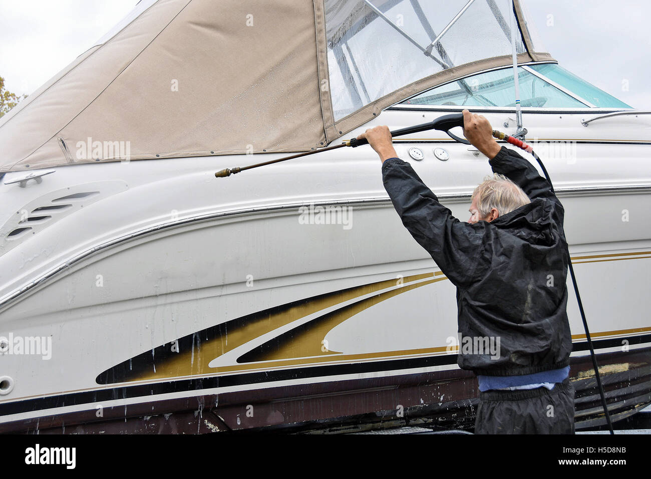 Kaukasischen Mann Motorboot mit Hochdruckreiniger reinigen Stockfoto