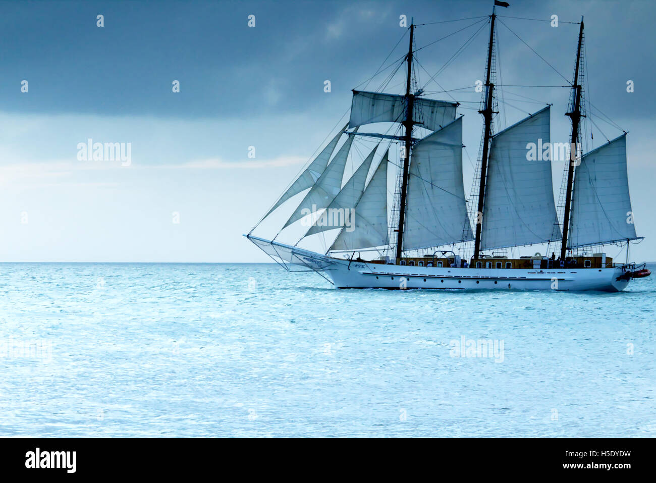 Ozean-Segelboot auf ruhigem Wasser mit stürmischen Hintergrund in der Nähe von Key West, Florida Stockfoto