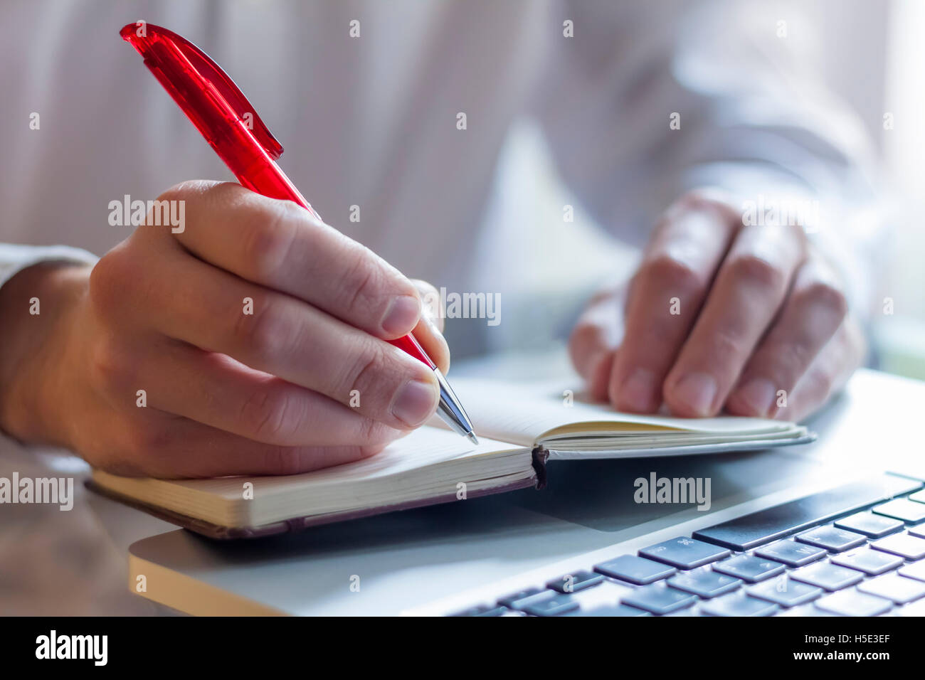 Geschäftsmann Notizen mit Laptop Hintergrund Stockfoto
