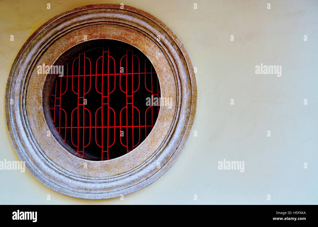 Traditionelle runde chinesische Tempel Fenster mit Metall geometrische Grill, reich Stein Texturen und Farben als "vintage Hintergrund mit Platz für Kopie Stockfoto