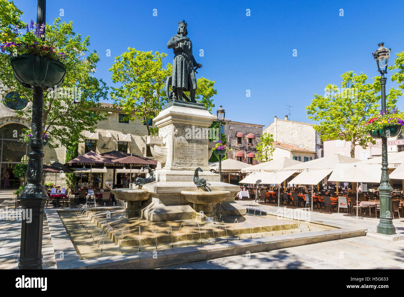 Statue von Saint-Louis auf einem Brunnen im Café gesäumten Place Saint-Louis, Aigues Mortes, Nimes, Gard, Frankreich Stockfoto