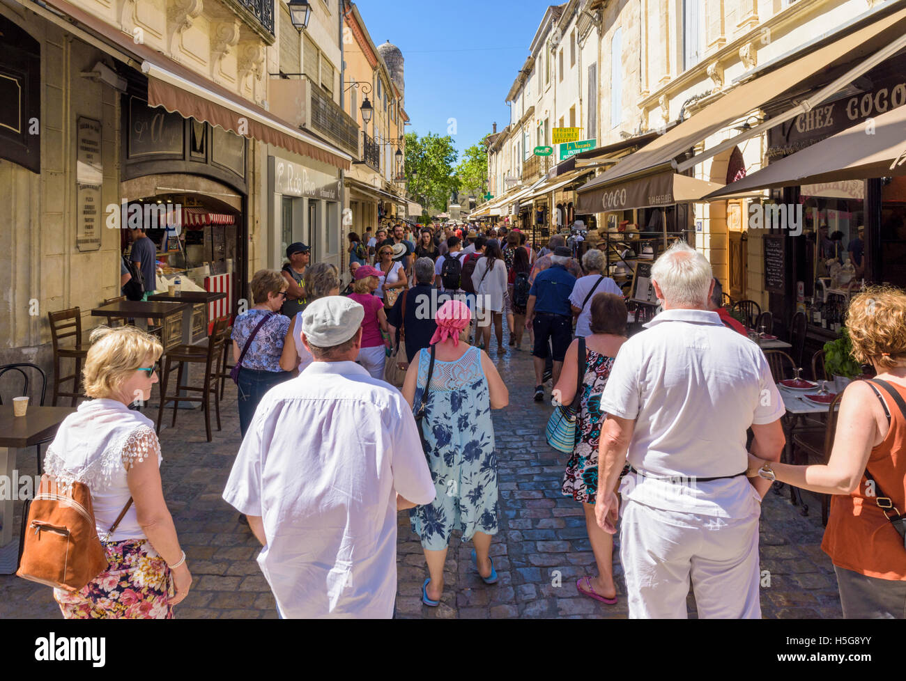 Touristen zu Fuß hinunter einen geschäftigen Shop gesäumten Straße in der mittelalterlichen Stadt Aigues-Mortes, Frankreich Stockfoto