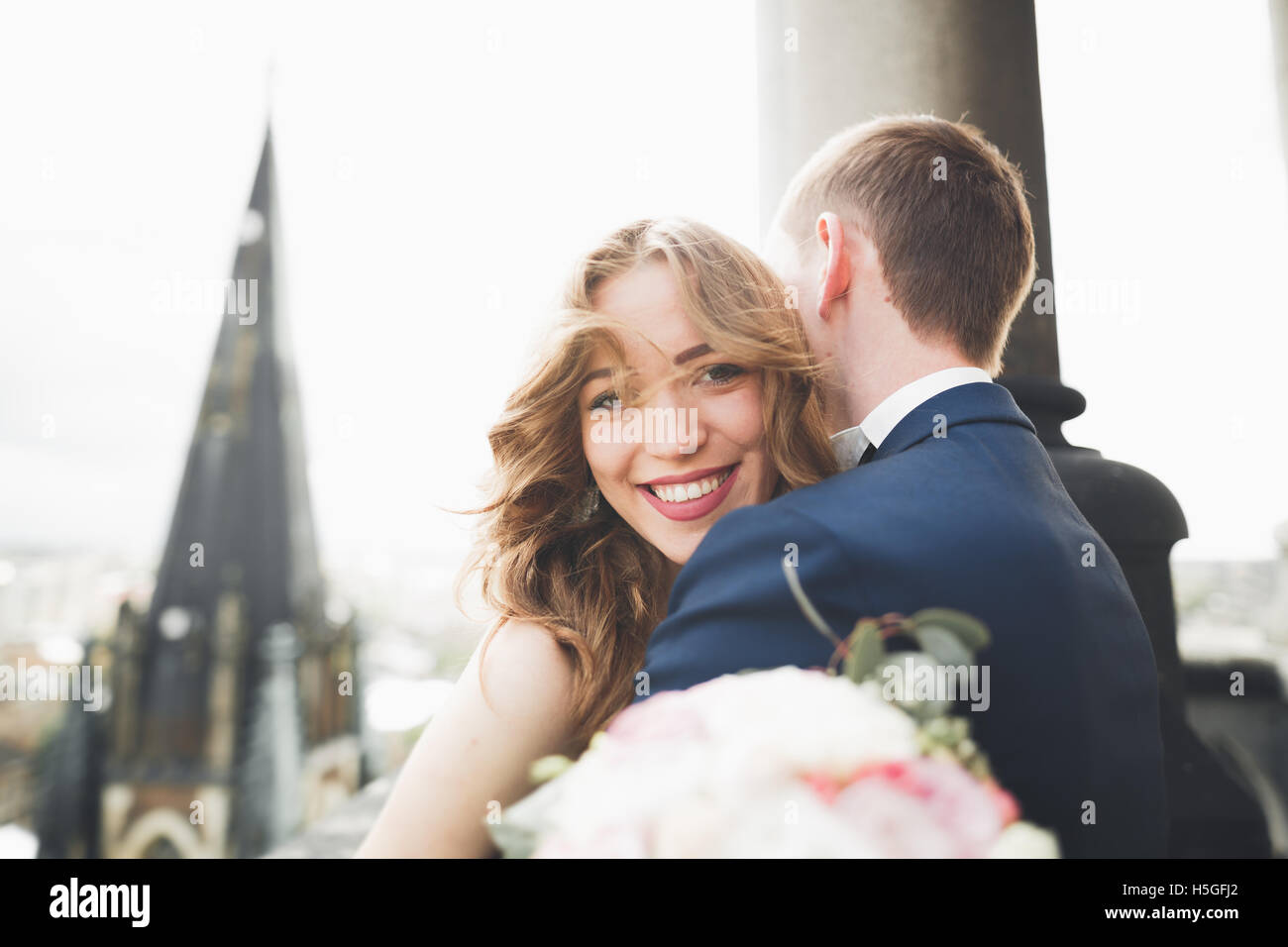 Schöne stilvolle Hochzeit paar küssen und umarmen auf Hintergrund Panoramablick auf die Altstadt Stockfoto