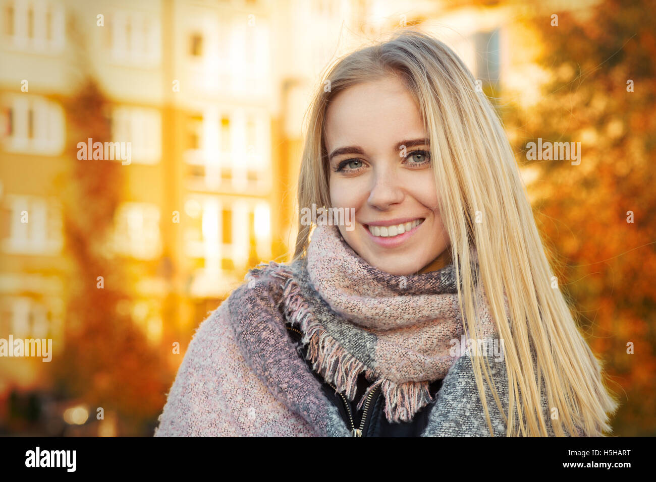 glückliche Frau lächelnd in Park bei herbstlichen Sonnenuntergang, getönten Bild Stockfoto