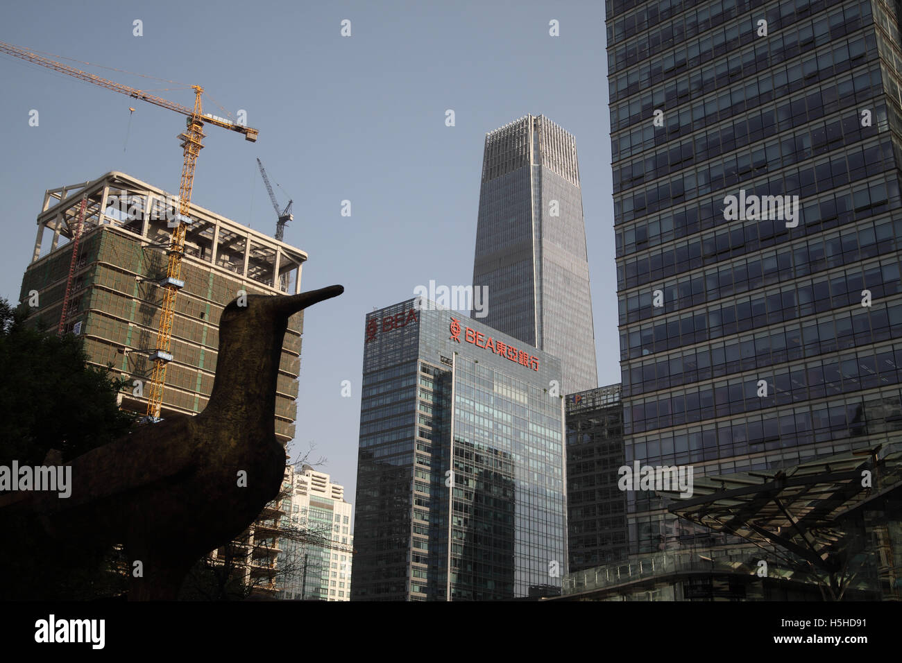 Große chinesische Architektur, die hoch World Trade Center # 3, Bank of East Asia oder BEA und Vogel-Silhouette Skulptur. Stockfoto