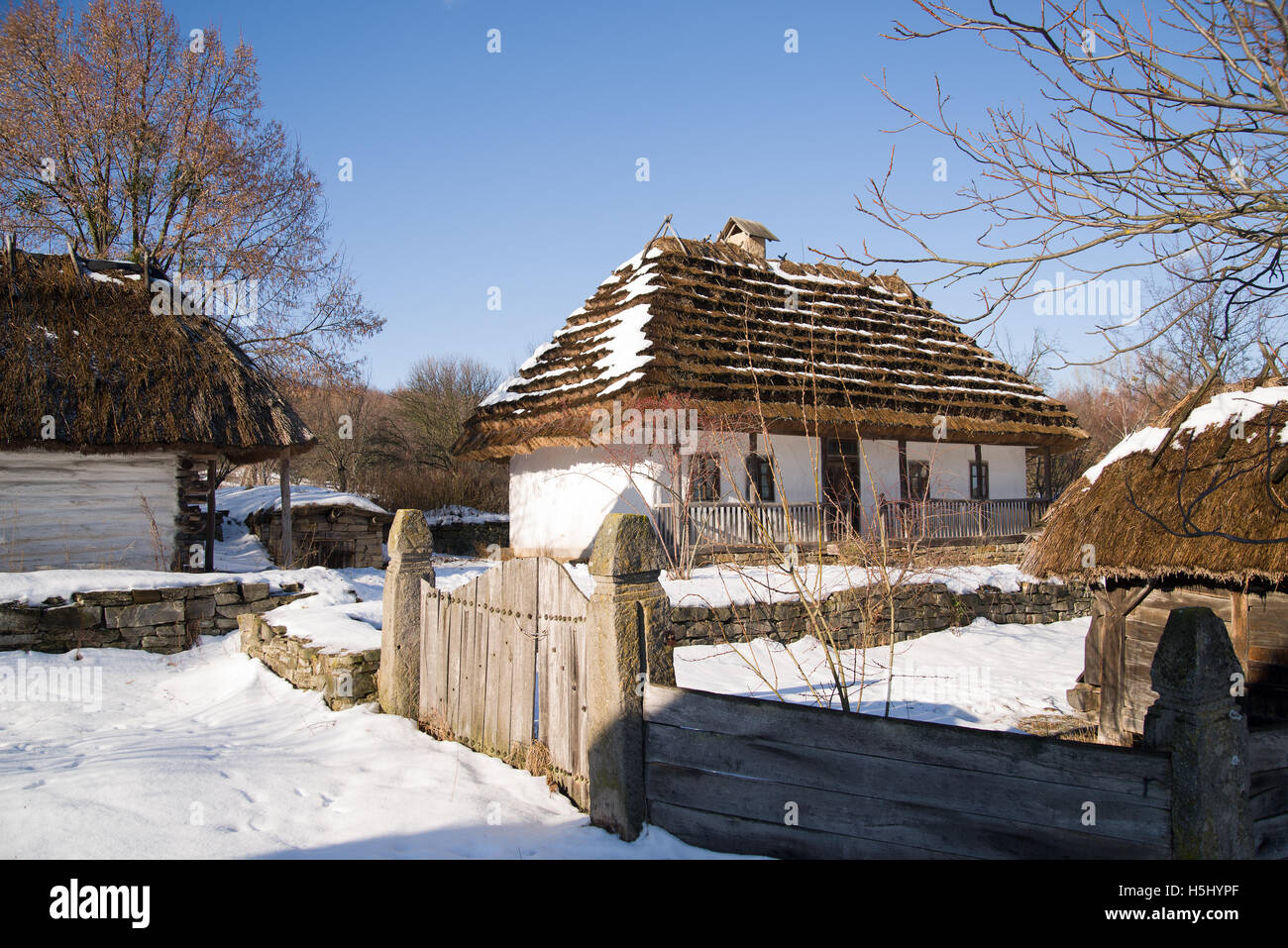 Altes Dorfhaus in der Ukraine im Winter an einem sonnigen Tag. Stockfoto
