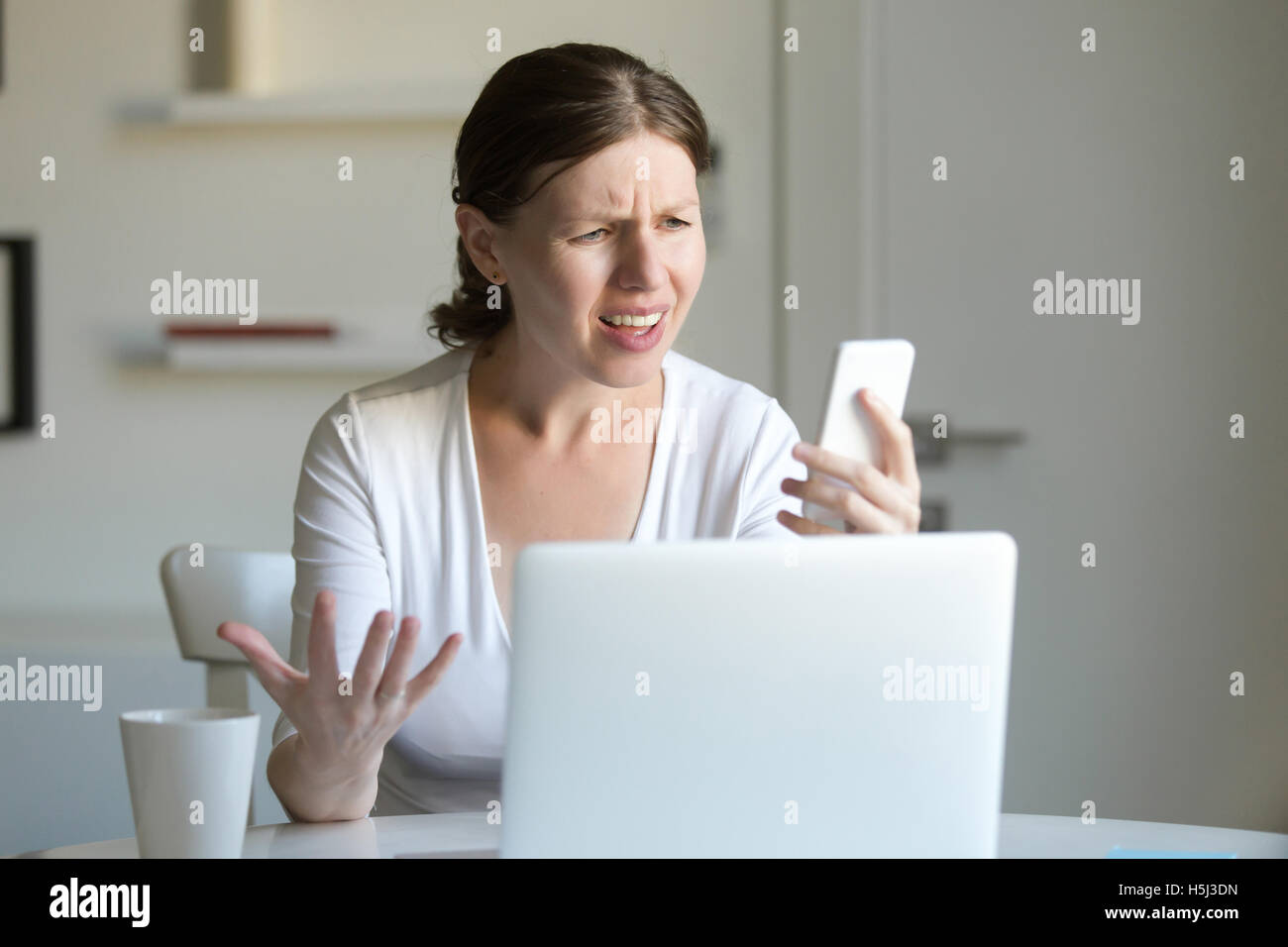 Porträt einer Frau das Notebook Bildschirm Handys betrachten Stockfoto