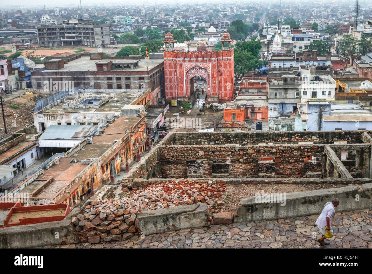 Ein Mann zu Fuß auf dem Weg, der zu Surya Mandir (Sun Temple), mit Galta Gate und ein Teil der Stadt Jaipur kann im Hintergrund gesehen werden. Jaipur, Indien. Stockfoto
