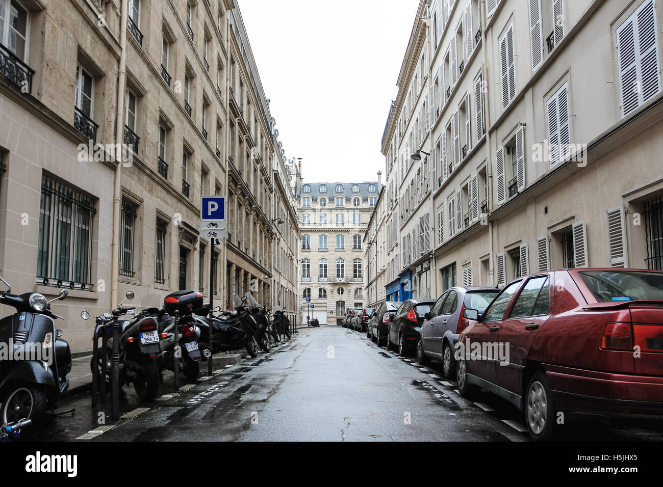 PARIS, Frankreich - 31. Dezember 2011: Typisch Paris Straßenansicht mit Parkplatz auf beiden Seiten der Straße: Motorräder und Autos Stockfoto