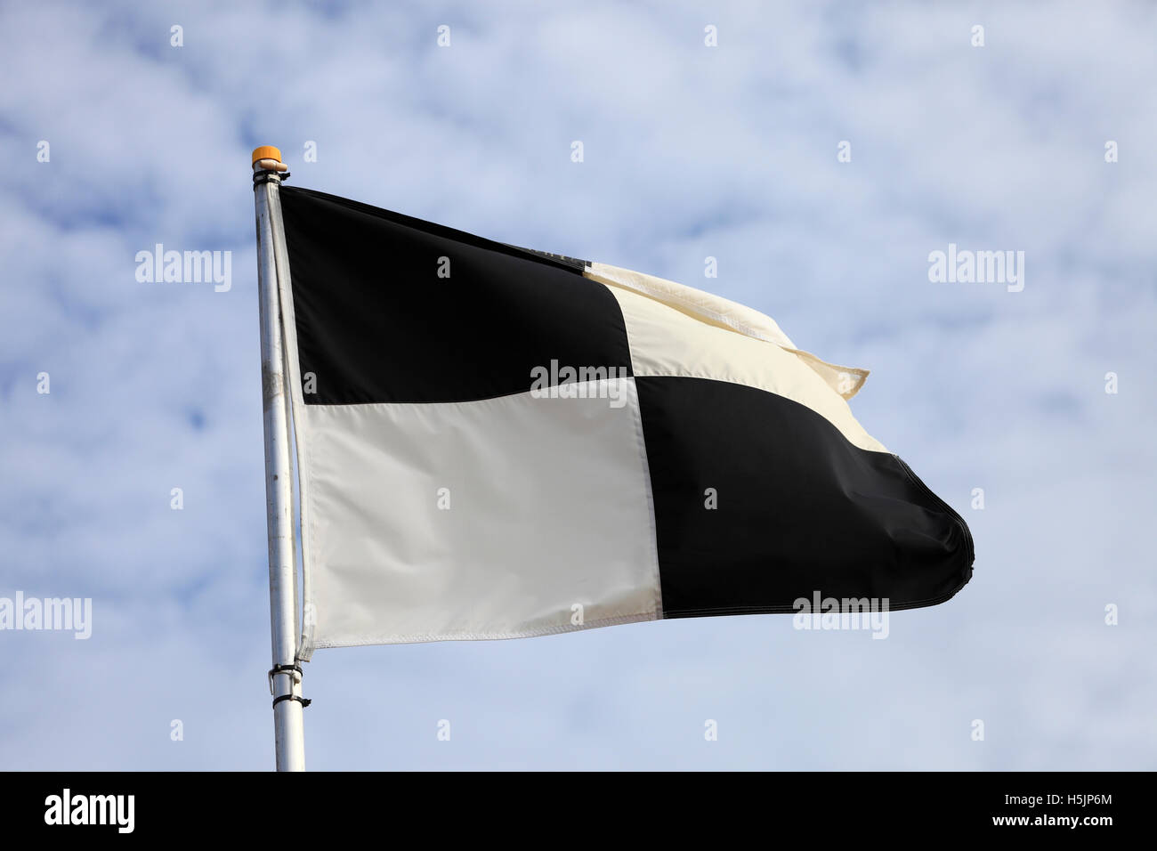 Schwarz / weiß karierte Flagge am Strand. Stockfoto