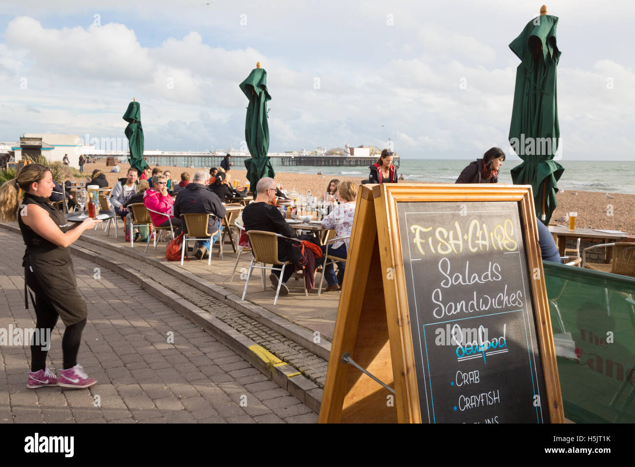 Eine Kellnerin in einem Café Fish &amp; Chips, Strand von Brighton, Brighton Sussex England UK Volk zu dienen Stockfoto