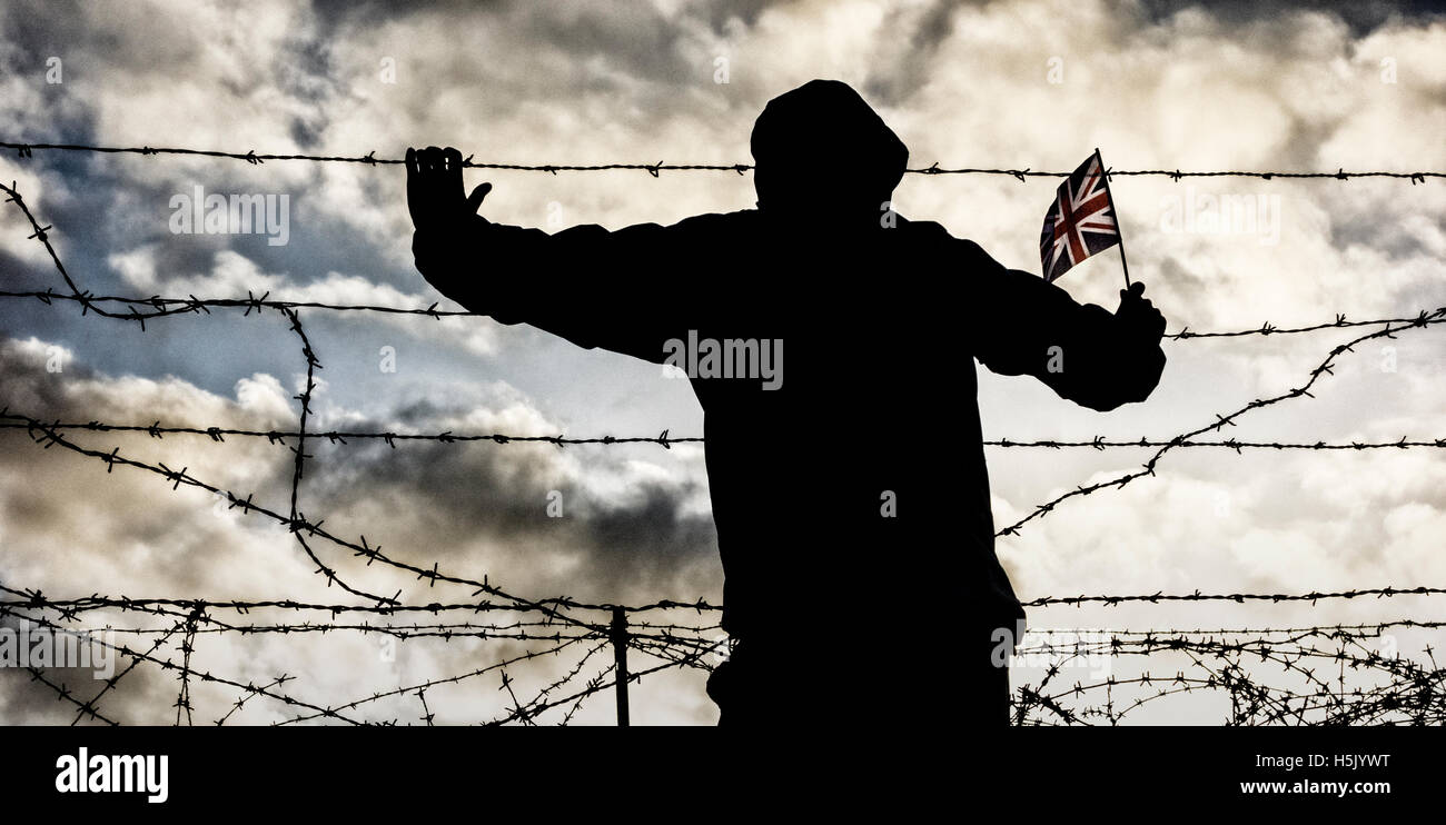 Rückansicht des Mann mit Kapuzenjacke mit Union Jack Flagge durch Stacheldraht Zaun suchen. Austritt, Einwanderung... Konzept Stockfoto