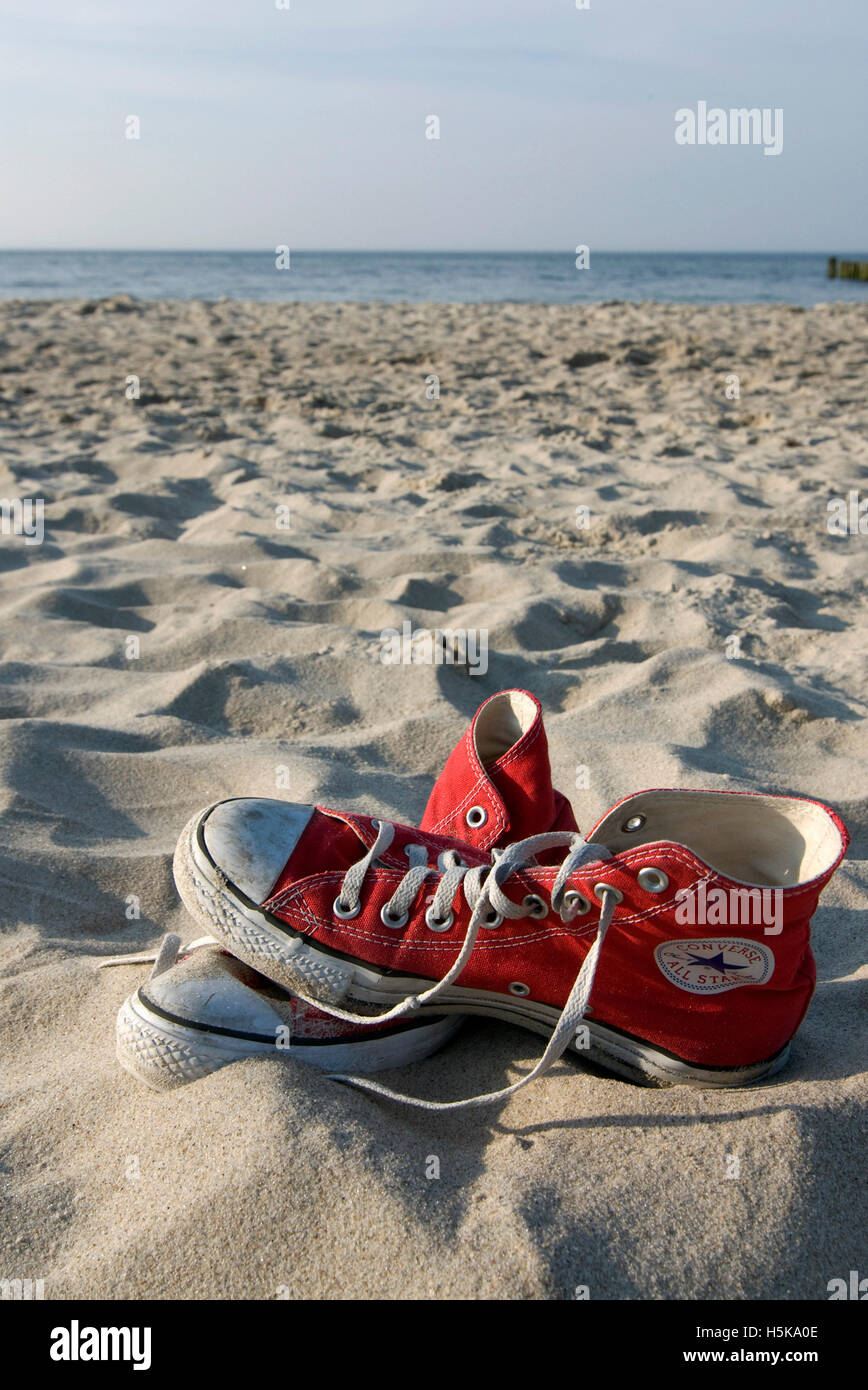 Roten Converse "Chucks" Sneakers in den sand Stockfoto