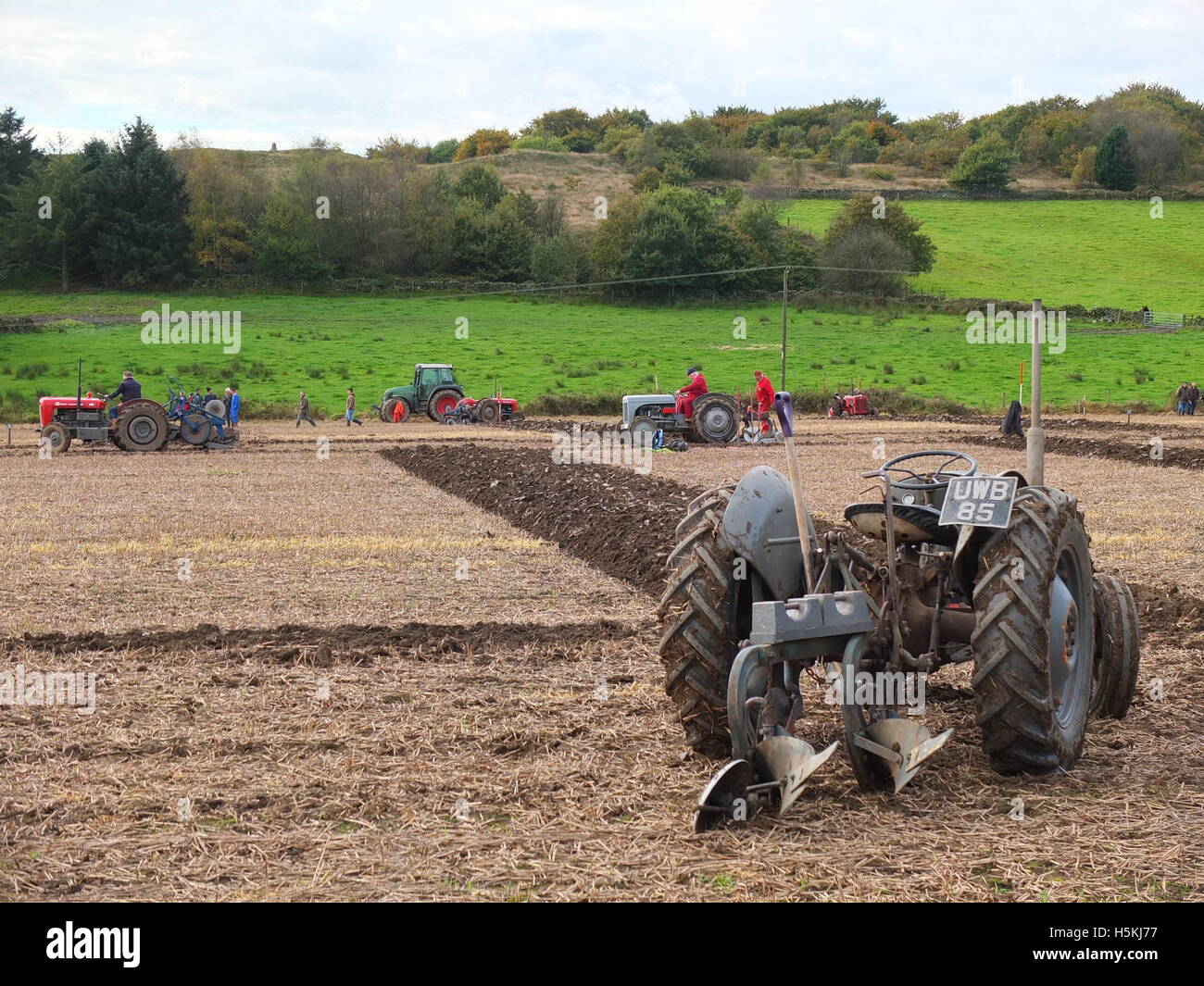 Stationäre Traktor im Vordergrund mit Konkurrenten hinter. Ashover Pflügen, Match, Highoredish Bauernhof, Derbyshire. Stockfoto