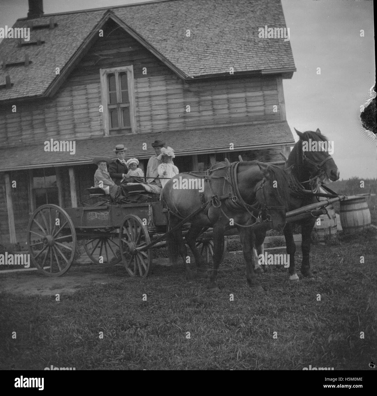 Ein historisches Foto, das die Familie Brebner auf einem Pferdewagen in Spruce Grove, Alberta, Kanada, zeigt. Die Szene fängt die Anfänge der Homesteading ein, wobei die Familie Pferdekutschen als Teil ihres täglichen Lebens verwendet. Stockfoto