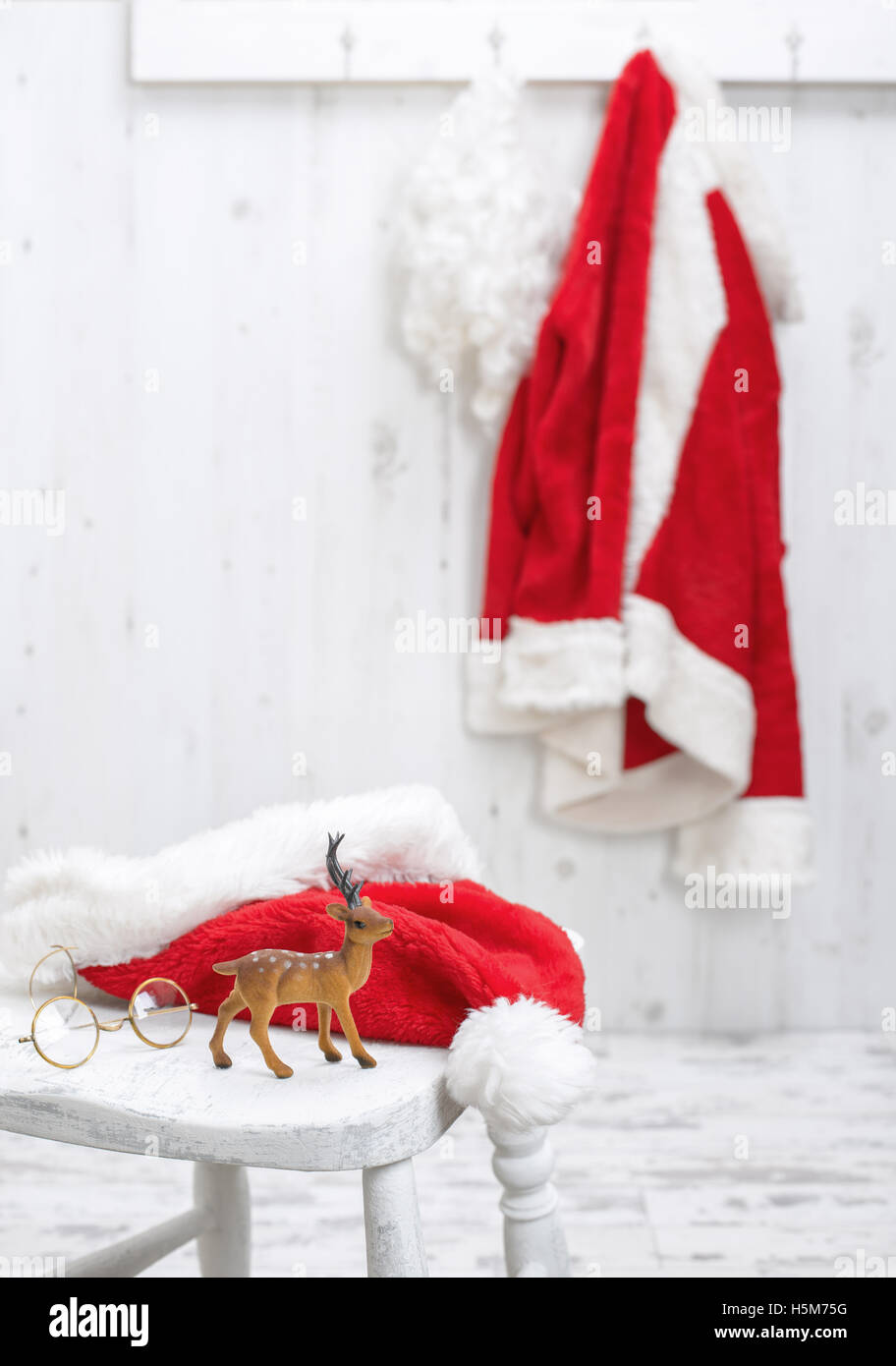 Rentier Figur mit Brille und Hut sitzt auf dem Flur des Weihnachtsmanns Stockfoto