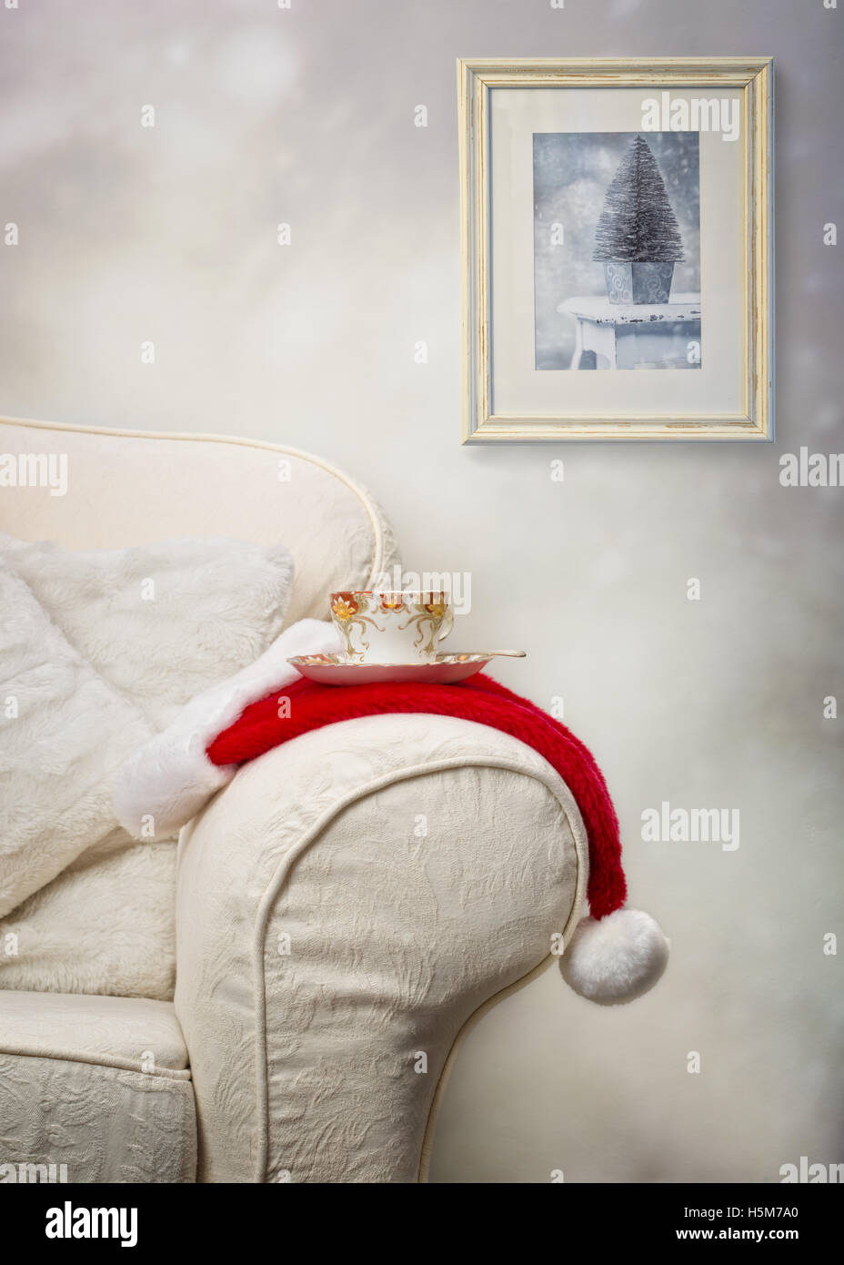 Tasse Tee auf Weihnachtsmütze mit Weihnachten Bild hängt im Hintergrund Stockfoto