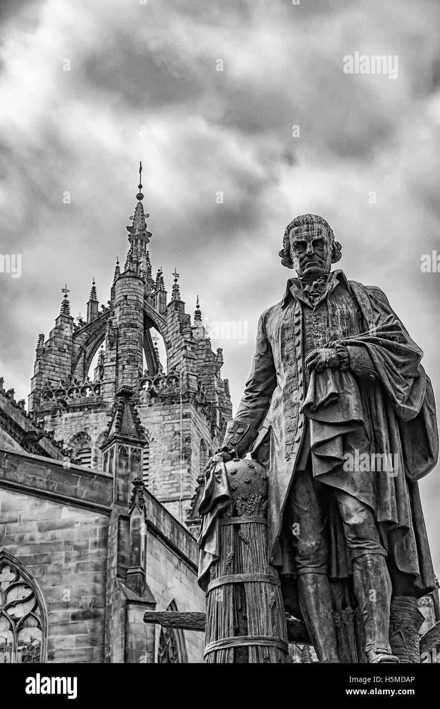 Statue des Ökonomen Adam Smith auf der Royal Mile in Edinburgh, die Hauptstadt von Schottland mit St. Giles Kathedrale im Hintergrund. Stockfoto
