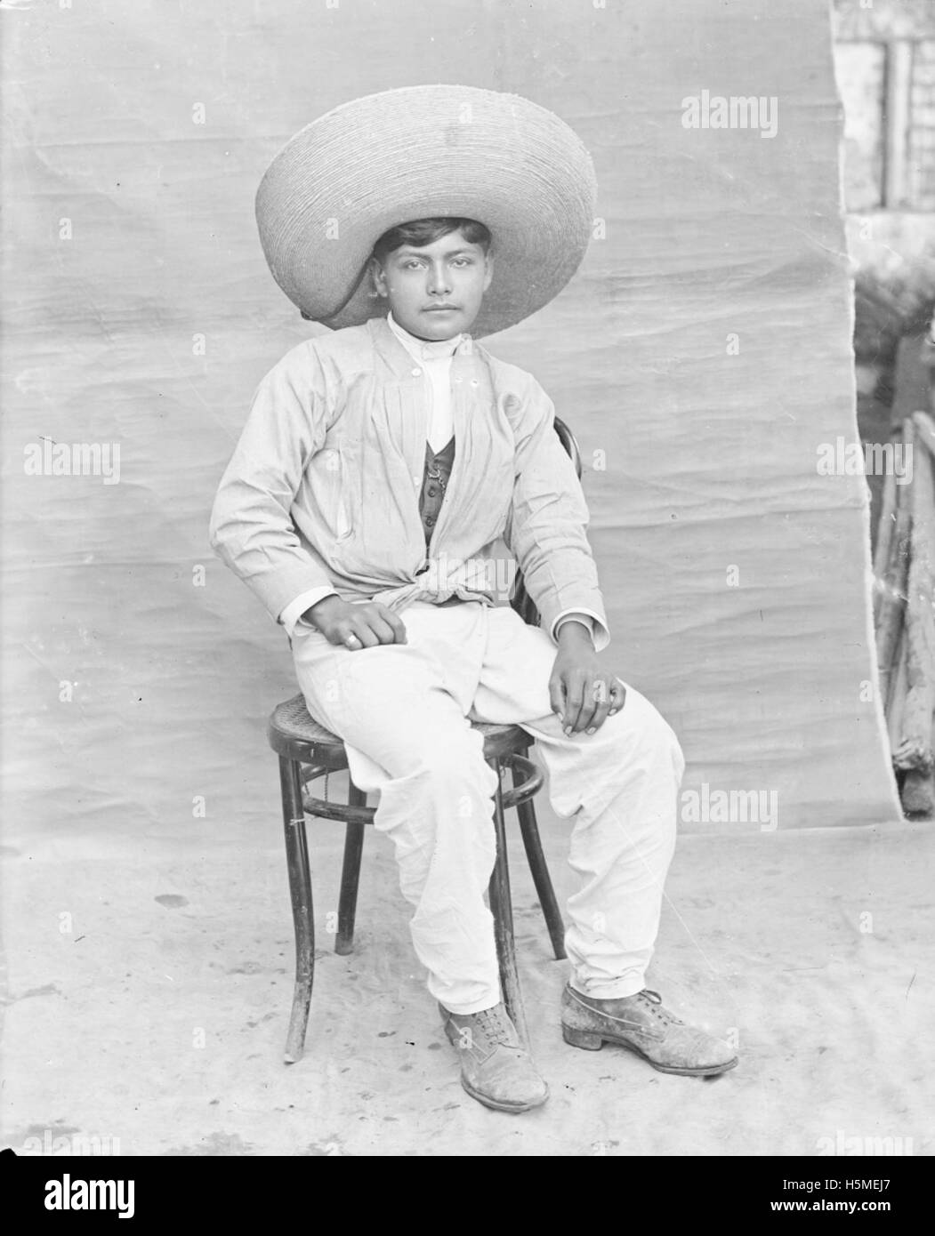 [Porträt eines jungen trägt Sombrero, auf Stuhl sitzend] Stockfoto