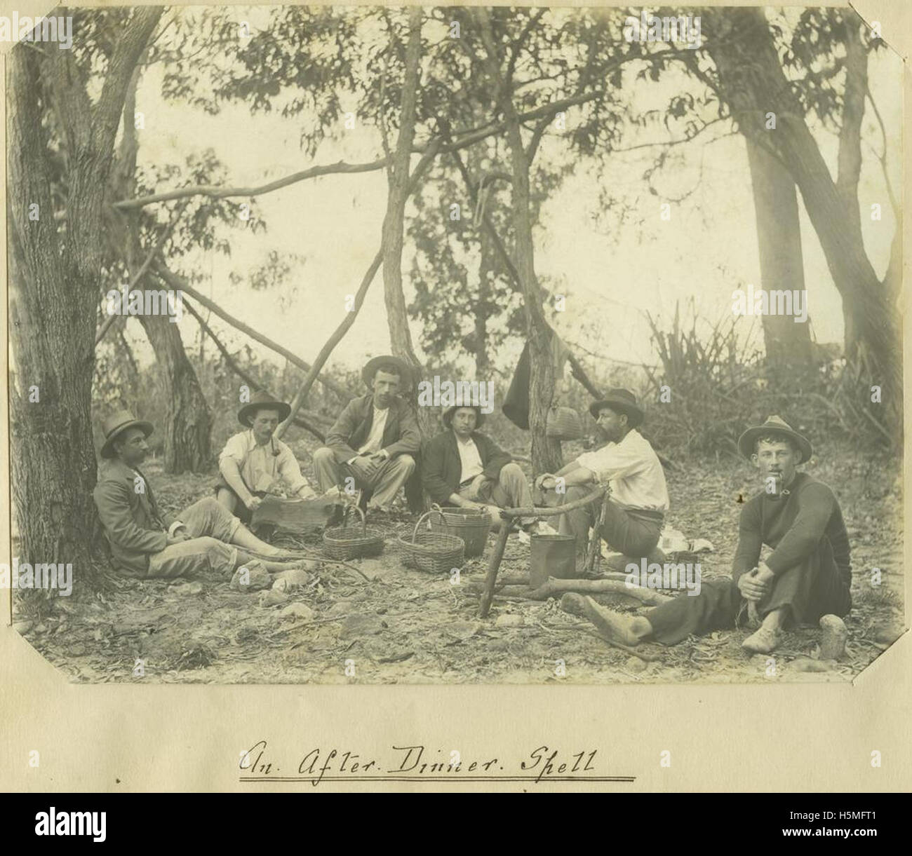 Dieses Bild zeigt Menschen, die sich nach dem Abendessen um ein Lagerfeuer versammelten und sich in einer entspannten Umgebung im Freien unterhalten, möglicherweise Geschichten erzählen. Stockfoto