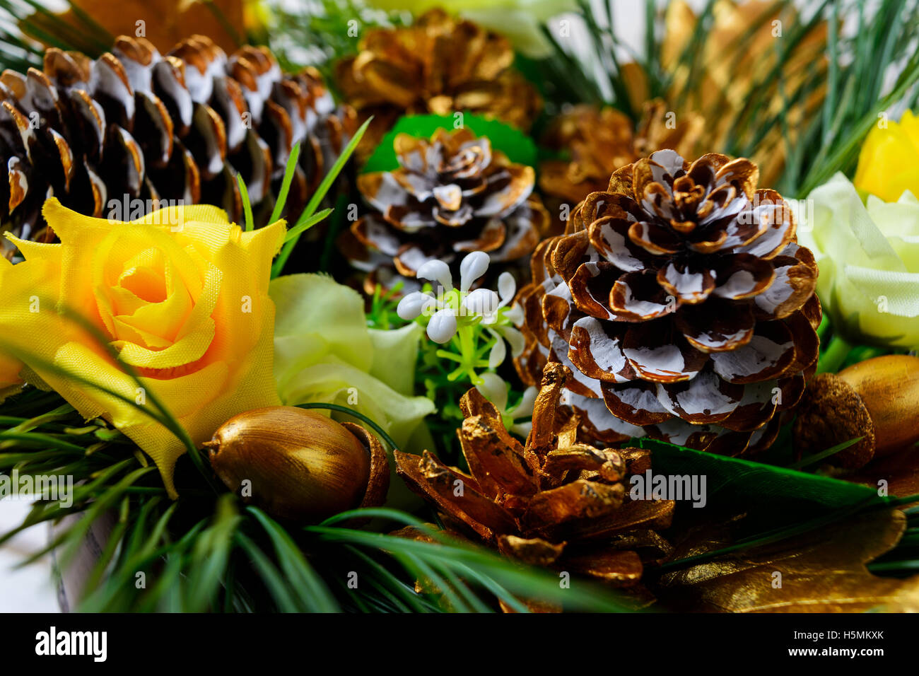 Weihnachts-Dekoration mit goldenen Tannenzapfen und Seidenrosen. Christmas Party Hintergrund, selektiven Fokus Stockfoto