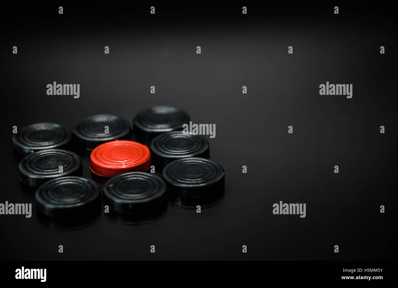 Red Pawn Schach in der Gruppe von schwarzen Bauern Schach mit schwarzem Hintergrund und selektiven Fokus Stockfoto