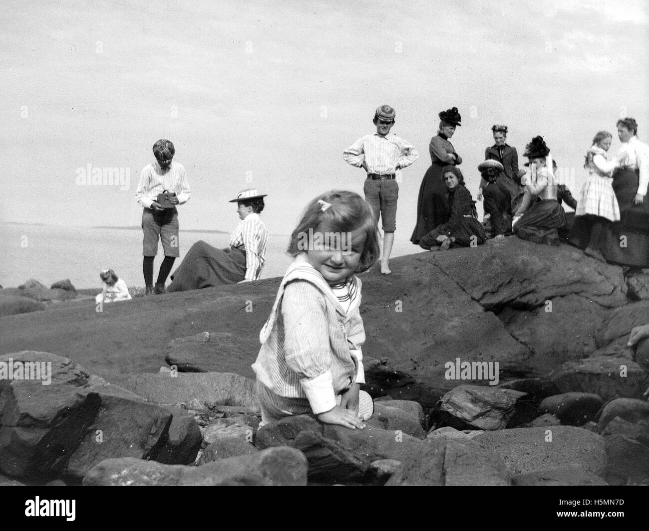 Im Juli 1900 versammelten sich Familien und Freunde zu einem Picknick am Ogier Point in Camden, Maine. Das Foto fängt einen Moment der Freizeit am Wasser ein und zeigt die malerische natürliche Umgebung und das gesellschaftliche Leben des frühen 20. Jahrhunderts in einer kleinen amerikanischen Stadt. Stockfoto