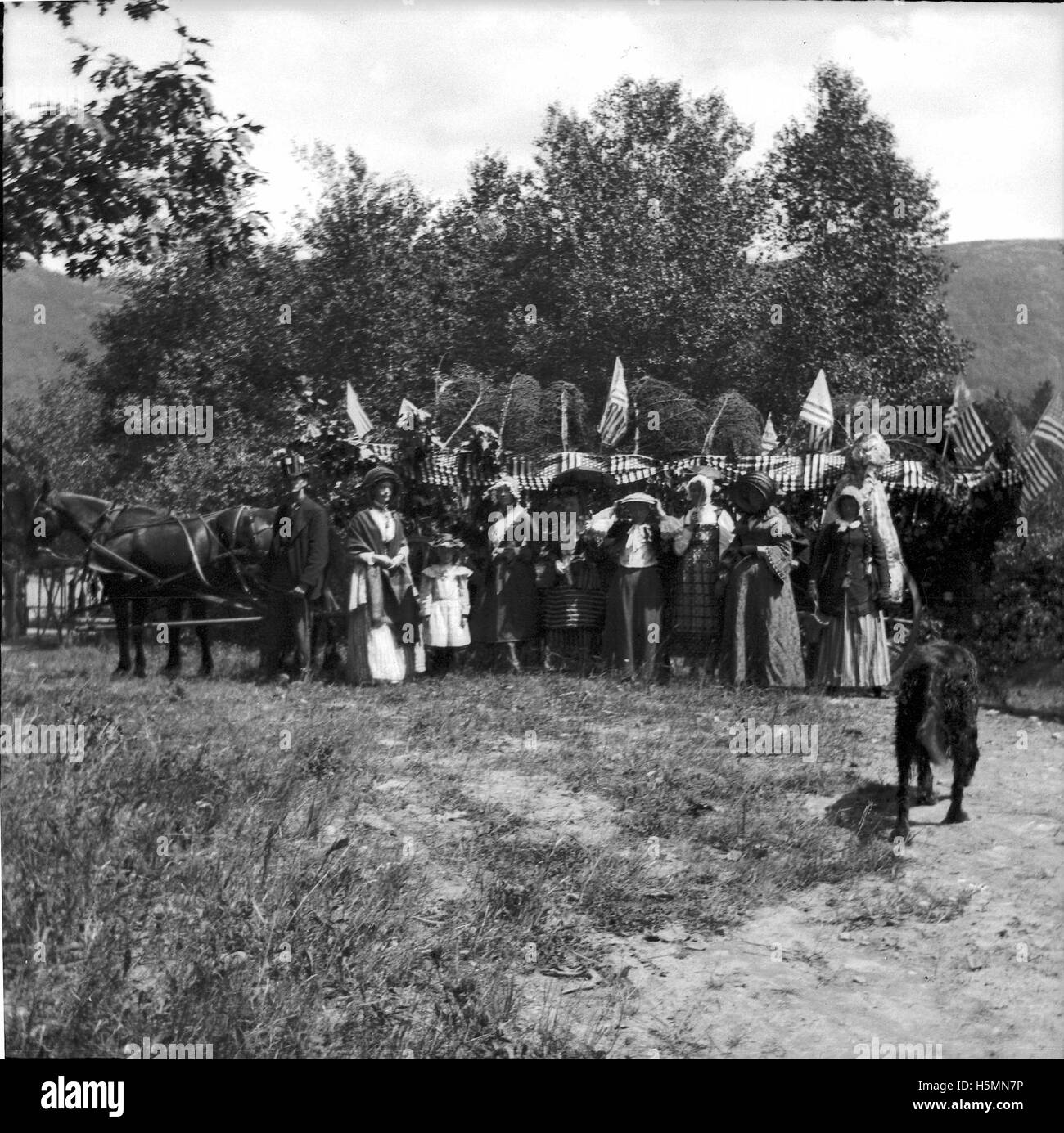 Ein Foto von Freunden und Familie von Theresa Babb, die 1898 auf einer dekorierten Heuhacke nach Lake City reiteten, wahrscheinlich für eine Feier wie den 4. Juli, mit Teilnehmern in historischer Kleidung und Flaggen. Stockfoto