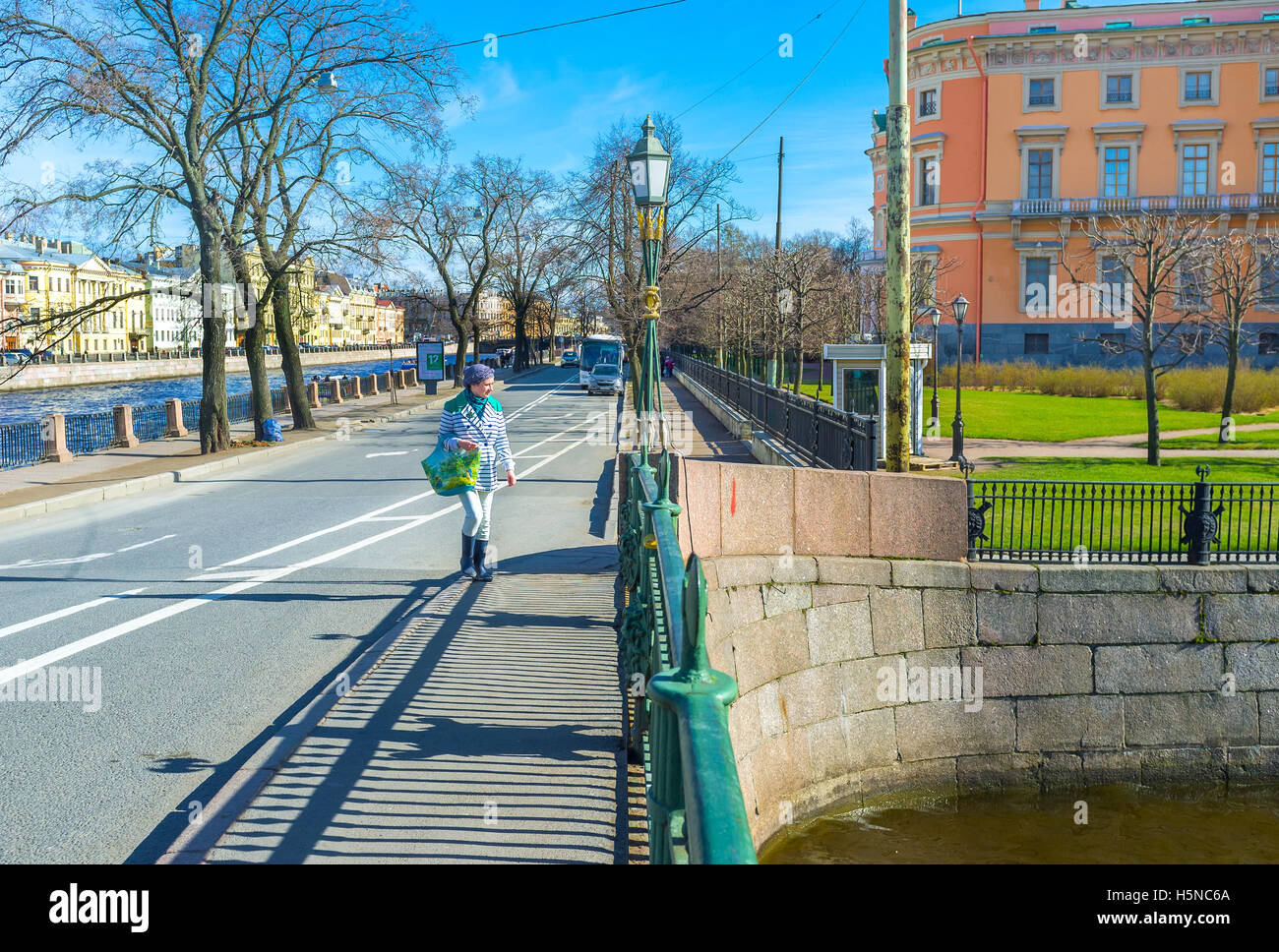 Der Spaziergang entlang der erste Ingenieur Brücke über Moyka mit der hellen orange Wand des St. Michael Schloss im Hintergrund Stockfoto