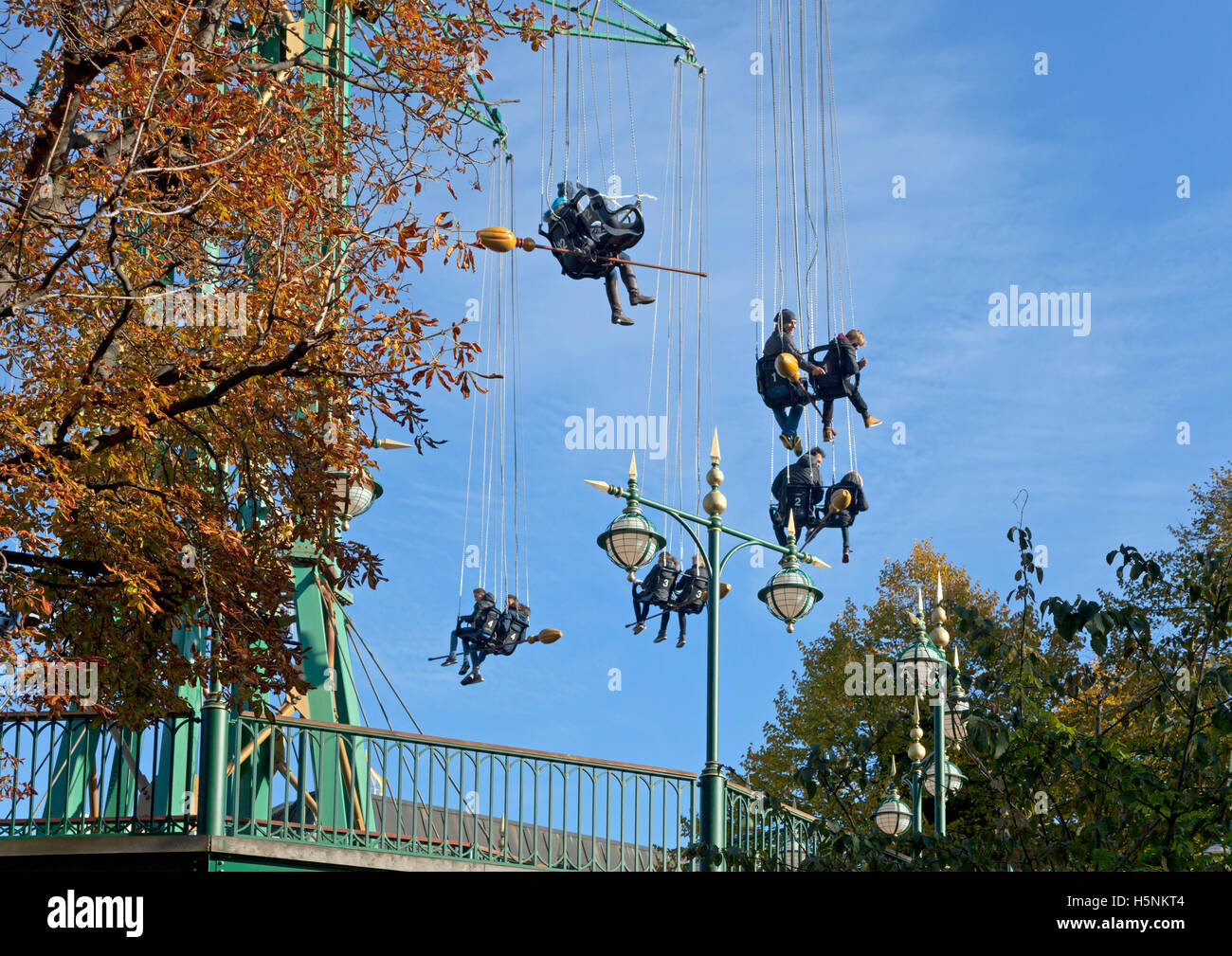 Jugendliche in der Nähe der Star Flyer Tour im Tivoli, Kopenhagen, an einem sonnigen Oktobertag. Halloween, besenstielen. Stockfoto