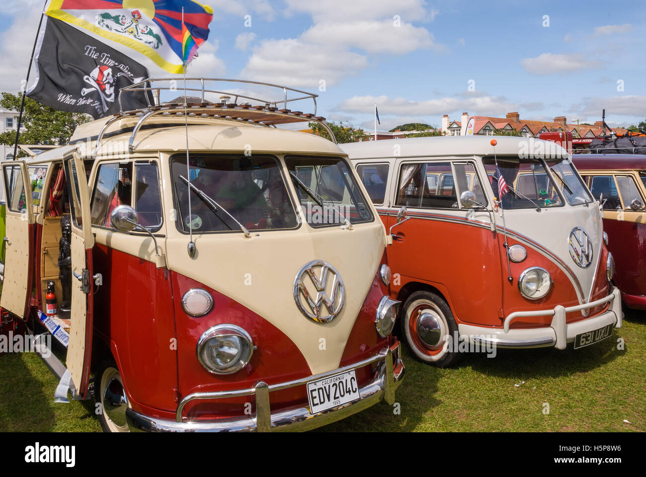 Zwei Teilen Bildschirm VW Wohnmobile auf Paignton Green mit einem bewölkten blauen Himmel im Hintergrund Stockfoto