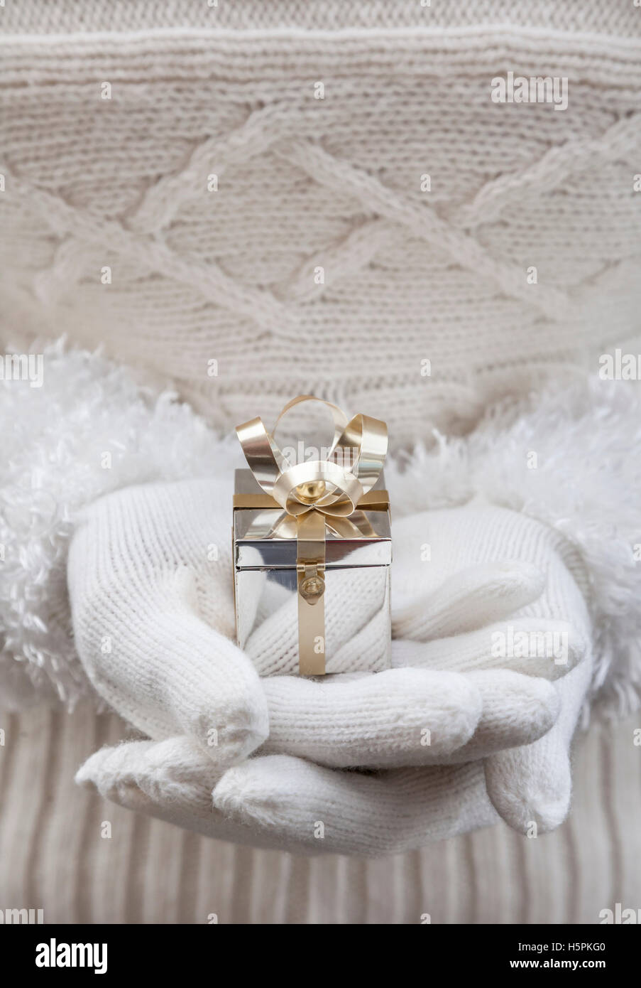 Nahaufnahme von Frauenhand in weißen Handschuhen halten kleine silberne Weihnachten Geschenk-box Stockfoto